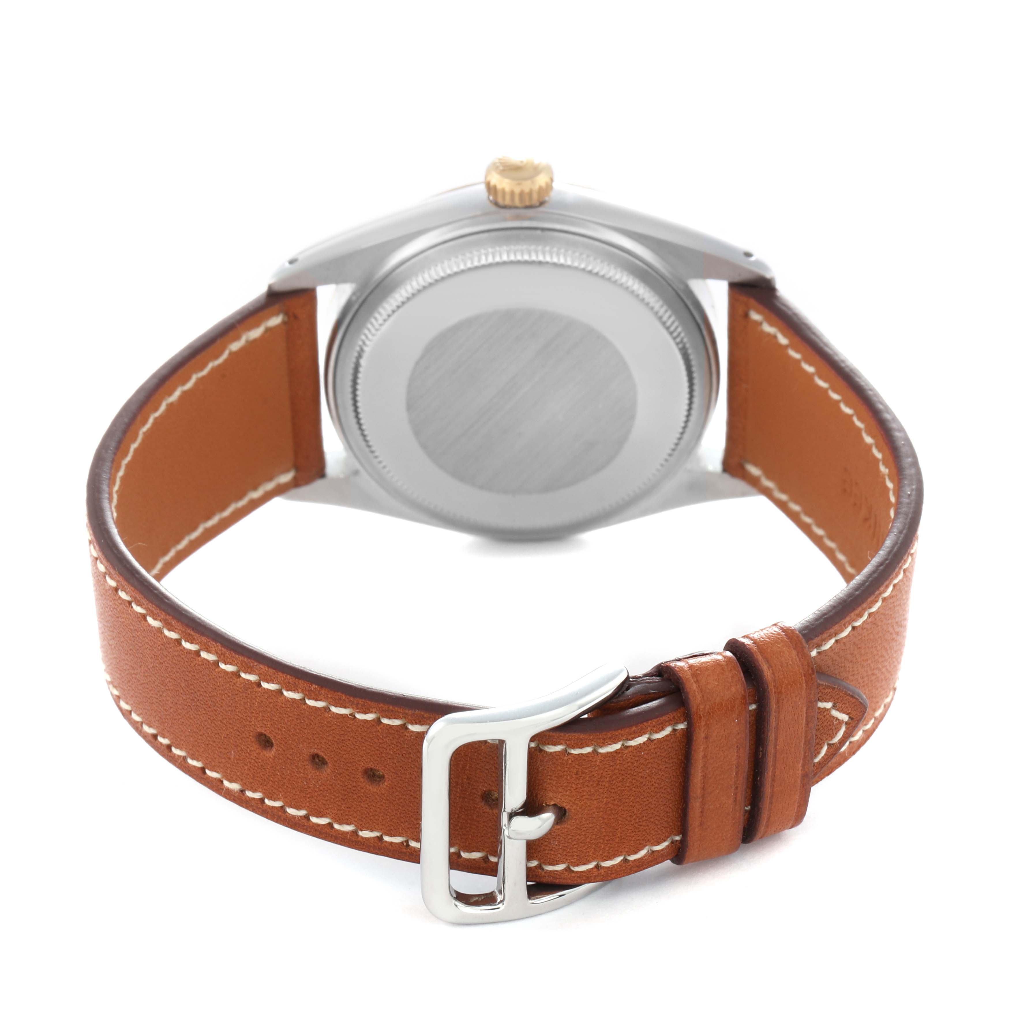 The Rolex Vintage Collection model 16013 is shown from the back, displaying its stainless steel case, gold crown, and brown leather strap with a buckle.