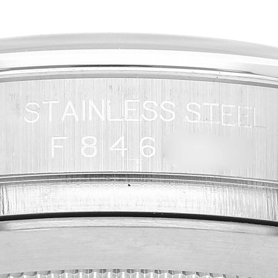 The image shows a close-up of the case back of a Rolex Daytona 116520 Men's Stainless Steel White Dial 116520 Men's Stainless Steel White Dial watch, focusing on the engraving that states it's made of stainless steel.