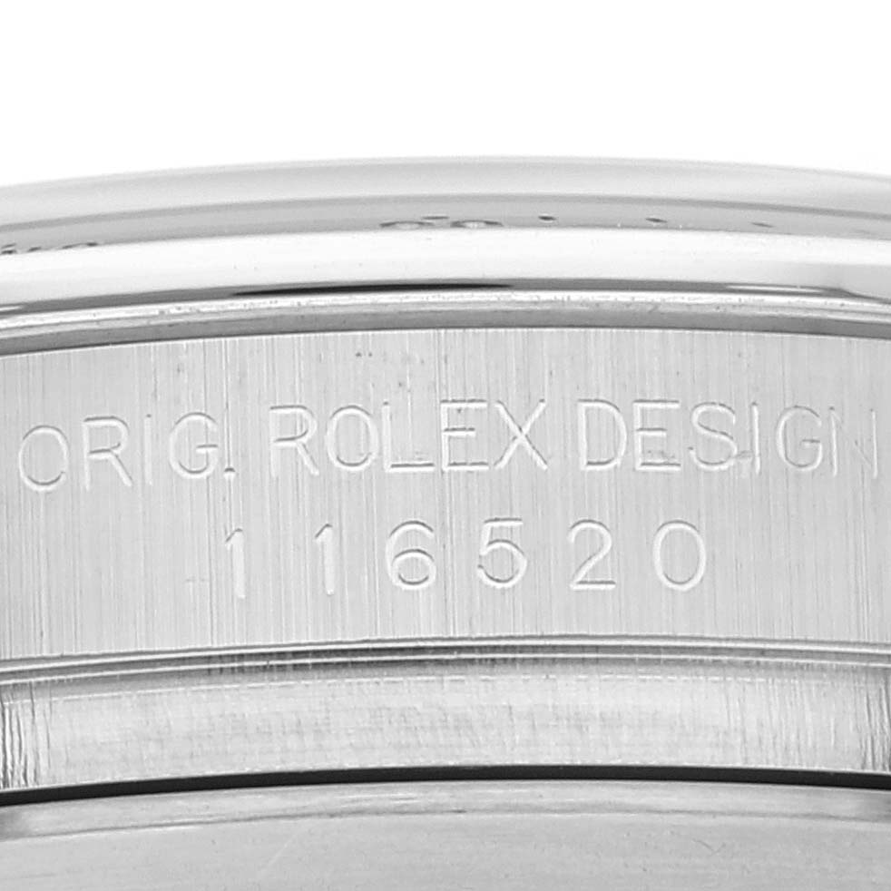 This close-up image shows the engraved serial number and "ORIG ROLEX DESIGN" on the case of a Rolex Daytona 116520 Men's Stainless Steel White Dial 116520 Men's Stainless Steel White Dial watch.
