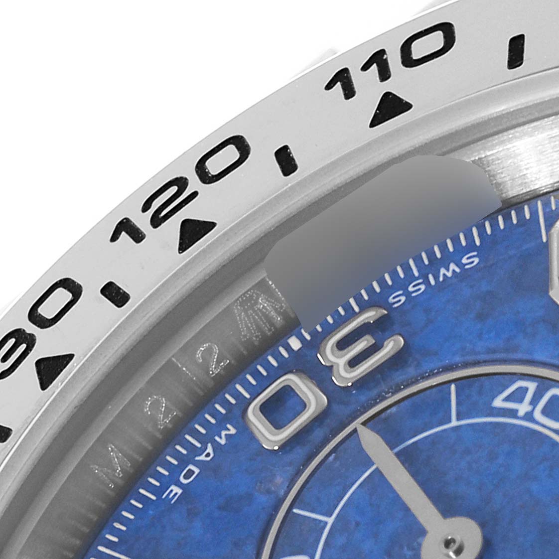 This close-up image shows the bezel and a partial view of the blue dial of the Rolex Daytona 116519 Men's White Gold Blue Dial 116519 Men's White Gold Blue Dial watch.
