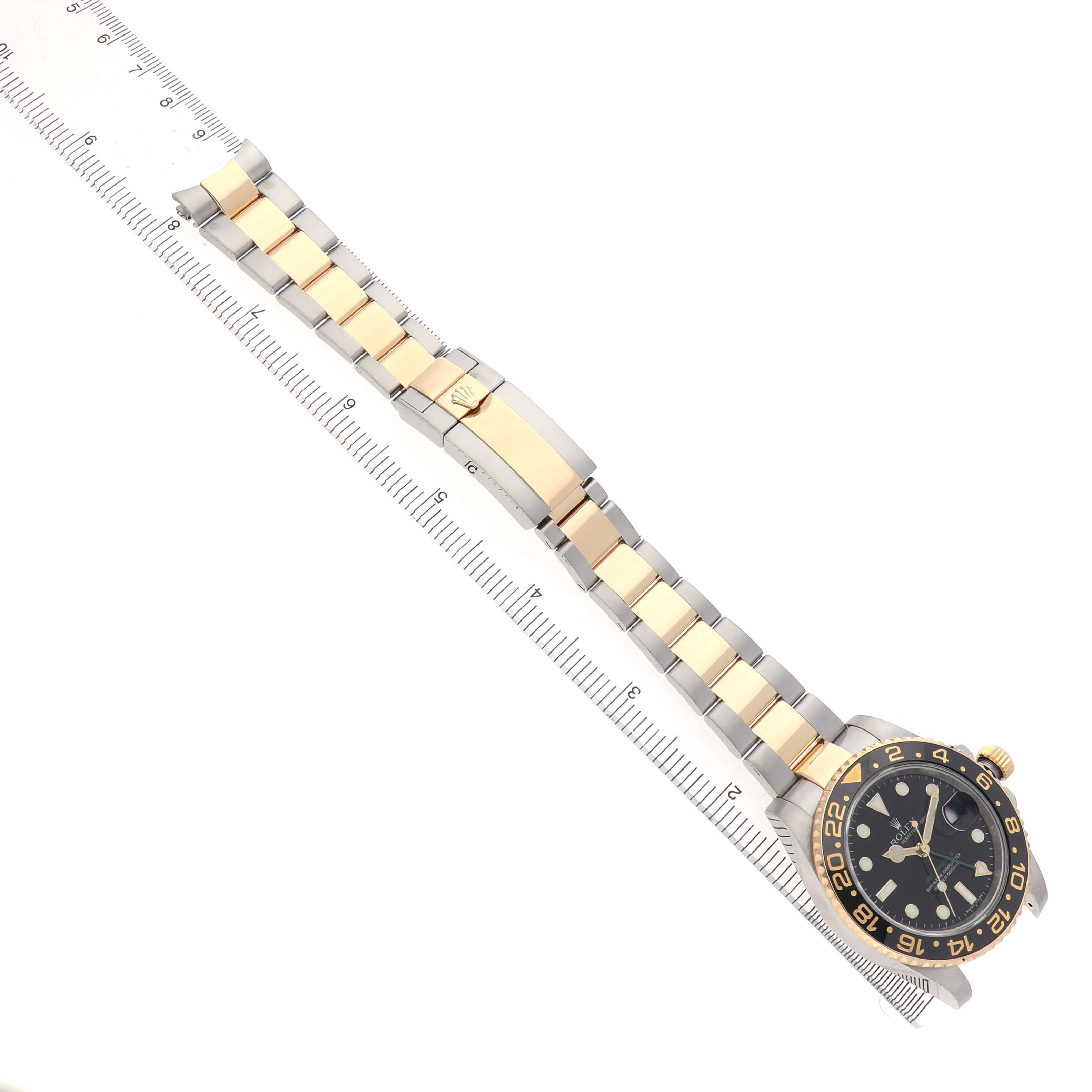 The image shows a Rolex GMT-Master 116713LN Men's Stainless Steel Black Dial watch from a top view, highlighting the bracelet and clasp along a ruler for size reference.