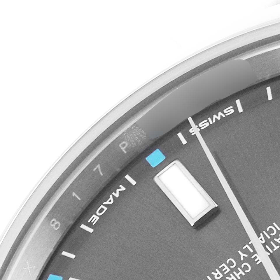 The image shows a close-up of the dial and part of the minute hand of the Rolex Oyster Perpetual 114300 Men's Stainless Steel Grey Dial 114300 Men's Stainless Steel Grey Dial watch.