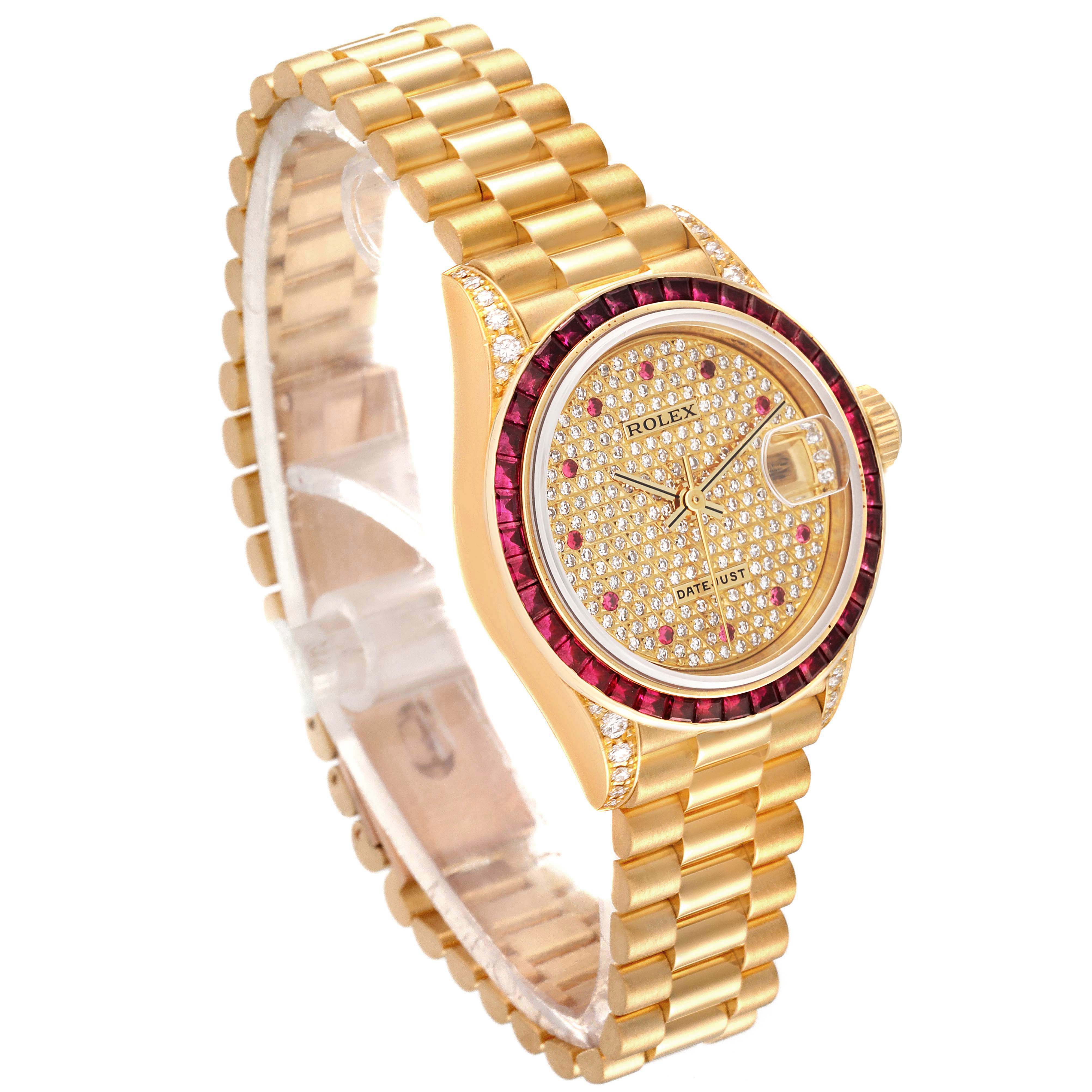 The image shows a Rolex President 69028 Women's Yellow Gold  69028 Women's Yellow Gold  watch at an angle displaying the gold bracelet, diamond-encrusted dial, and bezel with red gemstones.