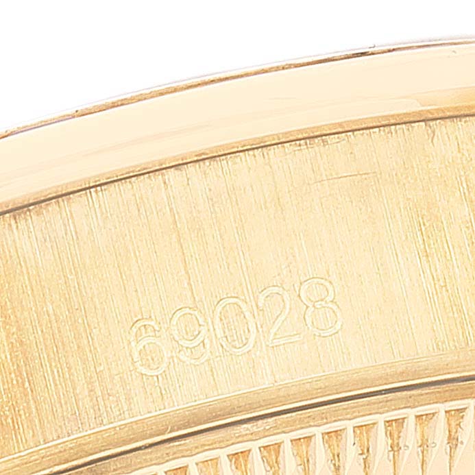 This close-up image shows part of the bracelet and the model number "69028" of a Rolex President 69028 Women's Yellow Gold  69028 Women's Yellow Gold  watch.