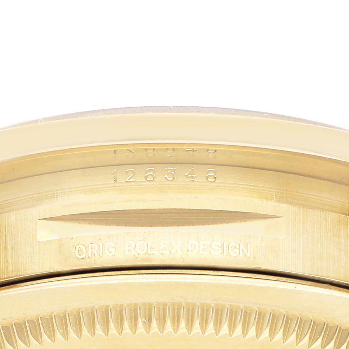 The image shows a close-up of the engraved side of a Rolex President 128348 Men's Yellow Gold Brown Dial watch, focusing on the bezel and edge details.