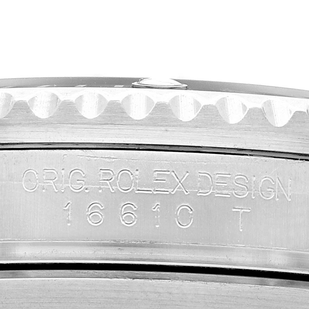 This close-up image of the Rolex Submariner 16610 Men
s Stainless Steel Black Dial 16610 Men
s Stainless Steel Black Dial watch shows part of the bezel and engraved model number 16610T.