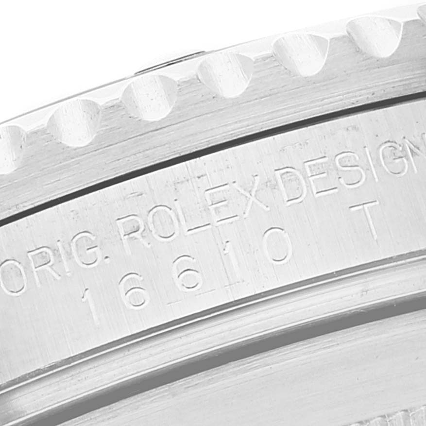 The image shows a macro shot of the engraving on the side of the bezel of a Rolex Submariner 16610 Men's Stainless Steel Black Dial 16610 Men's Stainless Steel Black Dial watch.