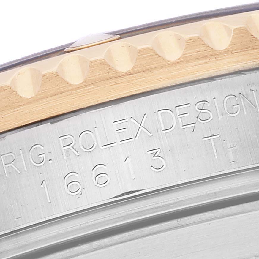 Close-up of the side view of a Rolex Submariner 16613 Men's Steel and Gold (two tone) Blue Dial 16613 Men's Steel and Gold (two tone) Blue Dial, showing the edge of the bezel and engraved serial number.