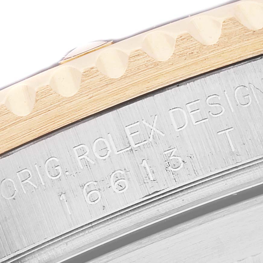 This image shows a close-up of the engraved side of a Rolex Submariner 16613 Men's Steel and Gold (two tone) Blue Dial 16613 Men's Steel and Gold (two tone) Blue Dial watch case, highlighting the bezel and model number.