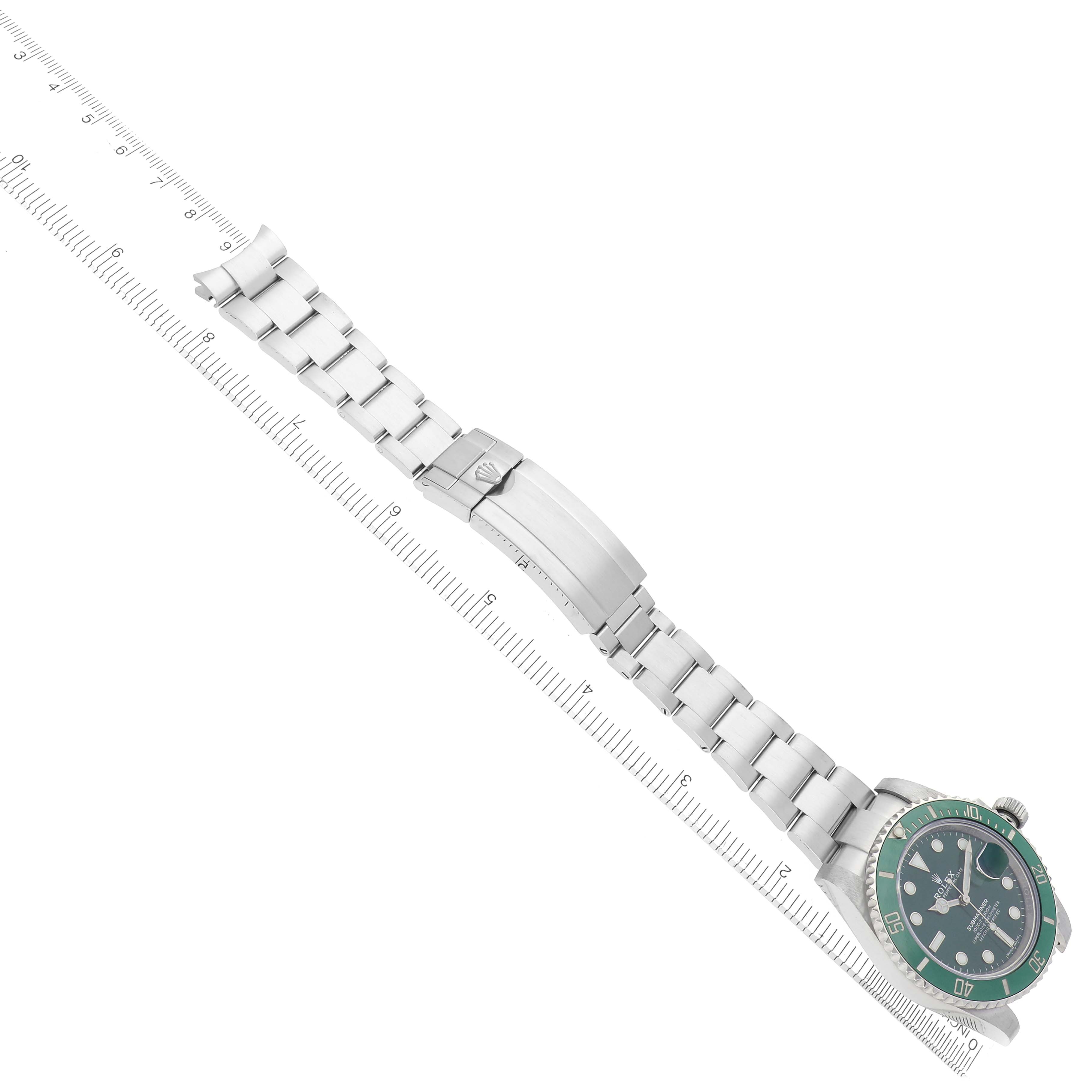 The image shows the Rolex Submariner model 116610LV watch laid flat, showcasing the bracelet, clasp, and watch face, with a ruler for scale.