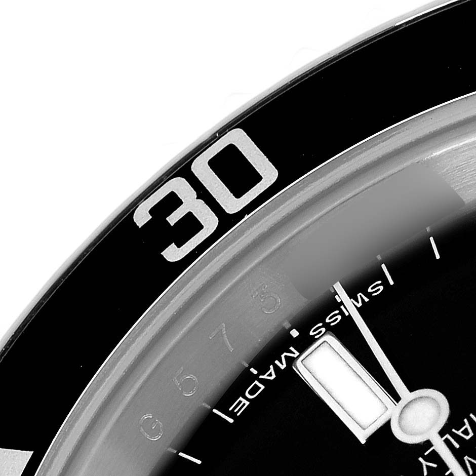 The image shows a close-up of the Rolex Submariner model 14060 watch, focusing on the bezel, dial markings, and part of the minute hand.