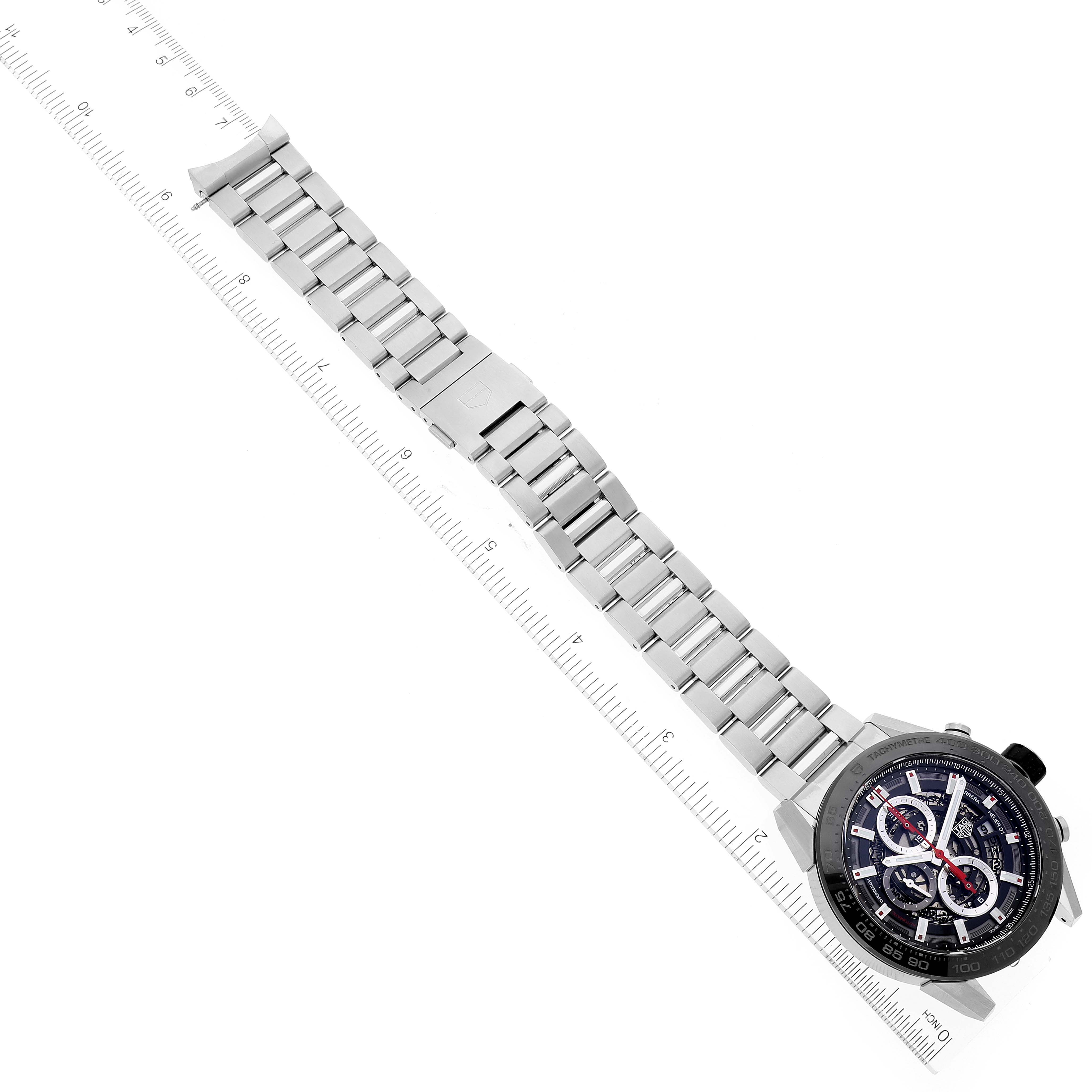 The image shows the face and band of a Tag Heuer Carrera CAR2A1W.BA0703 Men's Stainless Steel Transparent Dial CAR2A1W.BA0703 Men's Stainless Steel Transparent Dial watch at a diagonal angle, accompanied by a ruler for scale.