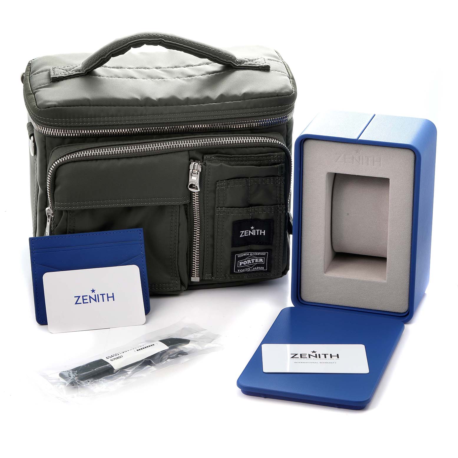 The image shows a Zenith Pilot model 49.4001.3652 watch case, accessory bag, warranty card, travel pouch, and additional strap.