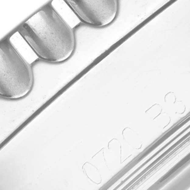 The image shows a close-up angle of the bezel with ridges and part of the case of a Breitling Navitimer AB0121A21B1A1 Men's Stainless Steel Grey Dial AB0121A21B1A1 Men's Stainless Steel Grey Dial watch with some engraved numbers.