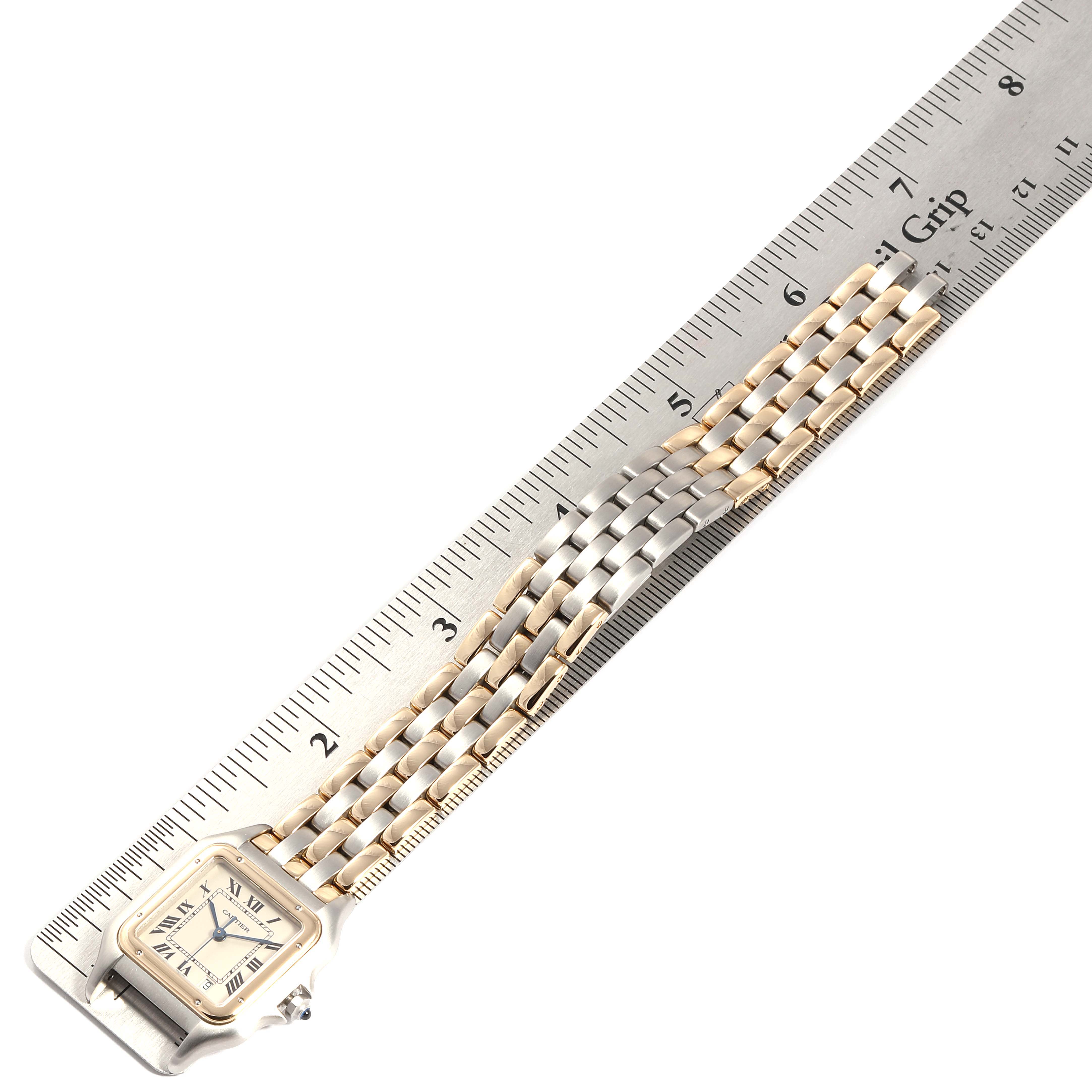 The image shows a Cartier Panthere W25028B6 Men's Steel and Gold (two tone) Silver Dial W25028B6 Men's Steel and Gold (two tone) Silver Dial model watch with a focus on its watch face and two-tone metal band placed alongside a ruler.