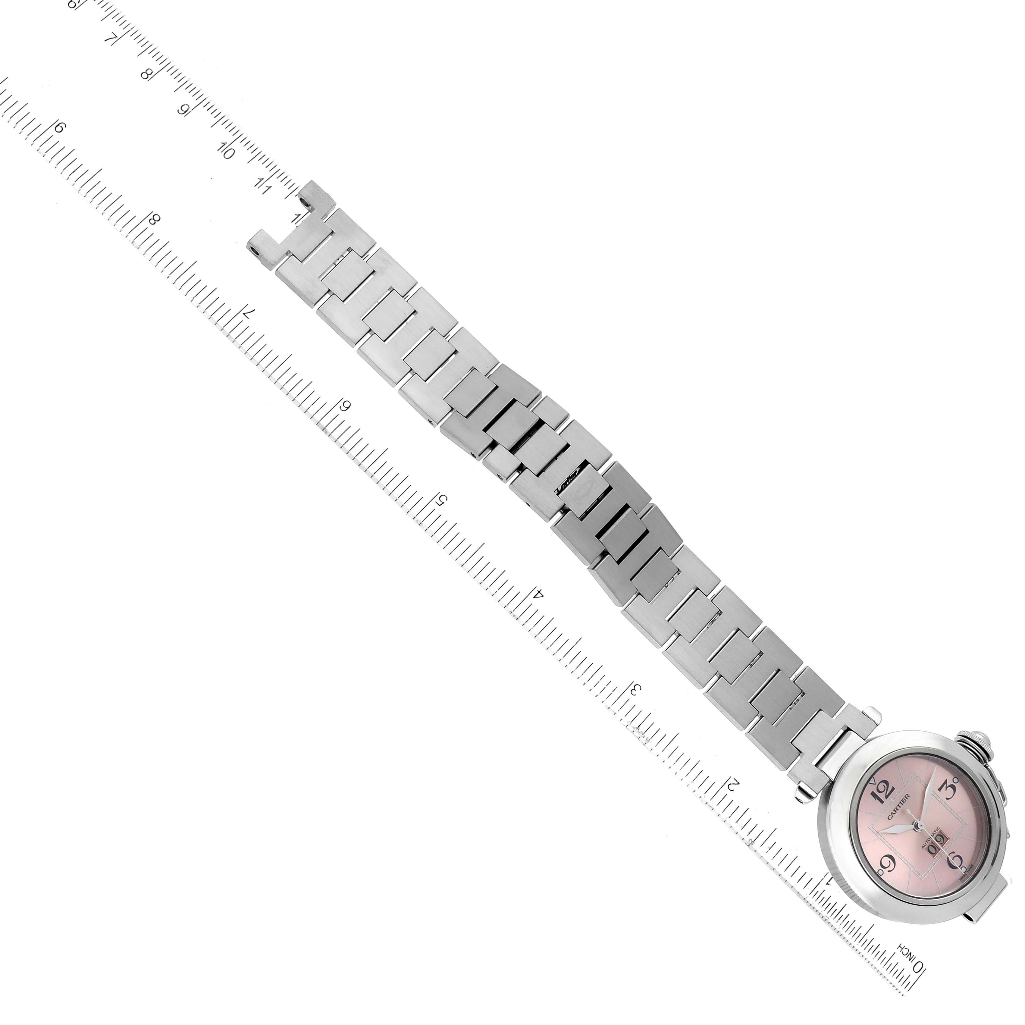 The image shows the stainless steel bracelet and face of a Pasha watch by Cartier placed next to a ruler for scale.