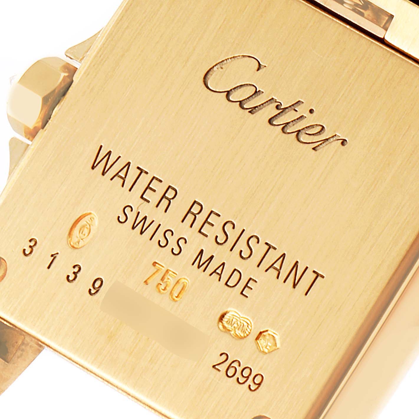 The image shows the back of a Cartier Santos Demoiselle WF9001Y7 Women
s Yellow Gold Silver Dial WF9001Y7 Women
s Yellow Gold Silver Dial watch, highlighting engravings such as water resistance, Swiss made, and hallmark stamps.