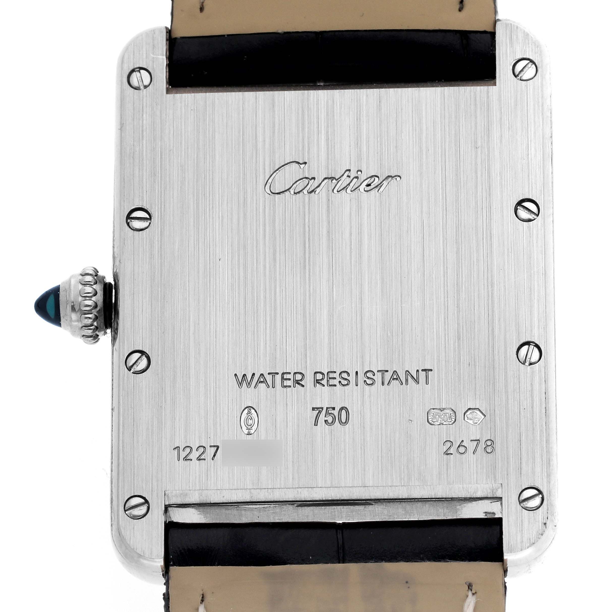 The image shows the back of the Cartier Tank Louis watch, model W1540956, featuring the brand inscription, water resistance details, and a gemstone crown.