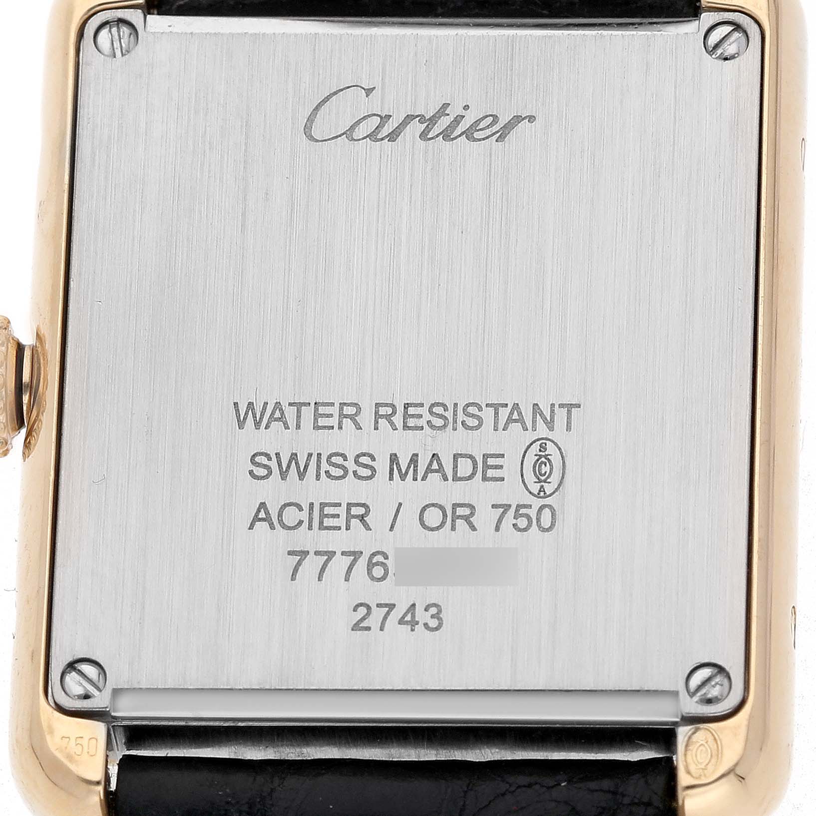 This image shows the back case of a Cartier Tank Solo W1018755 Women's Yellow Gold Silver Dial watch, displaying engravings and screws.