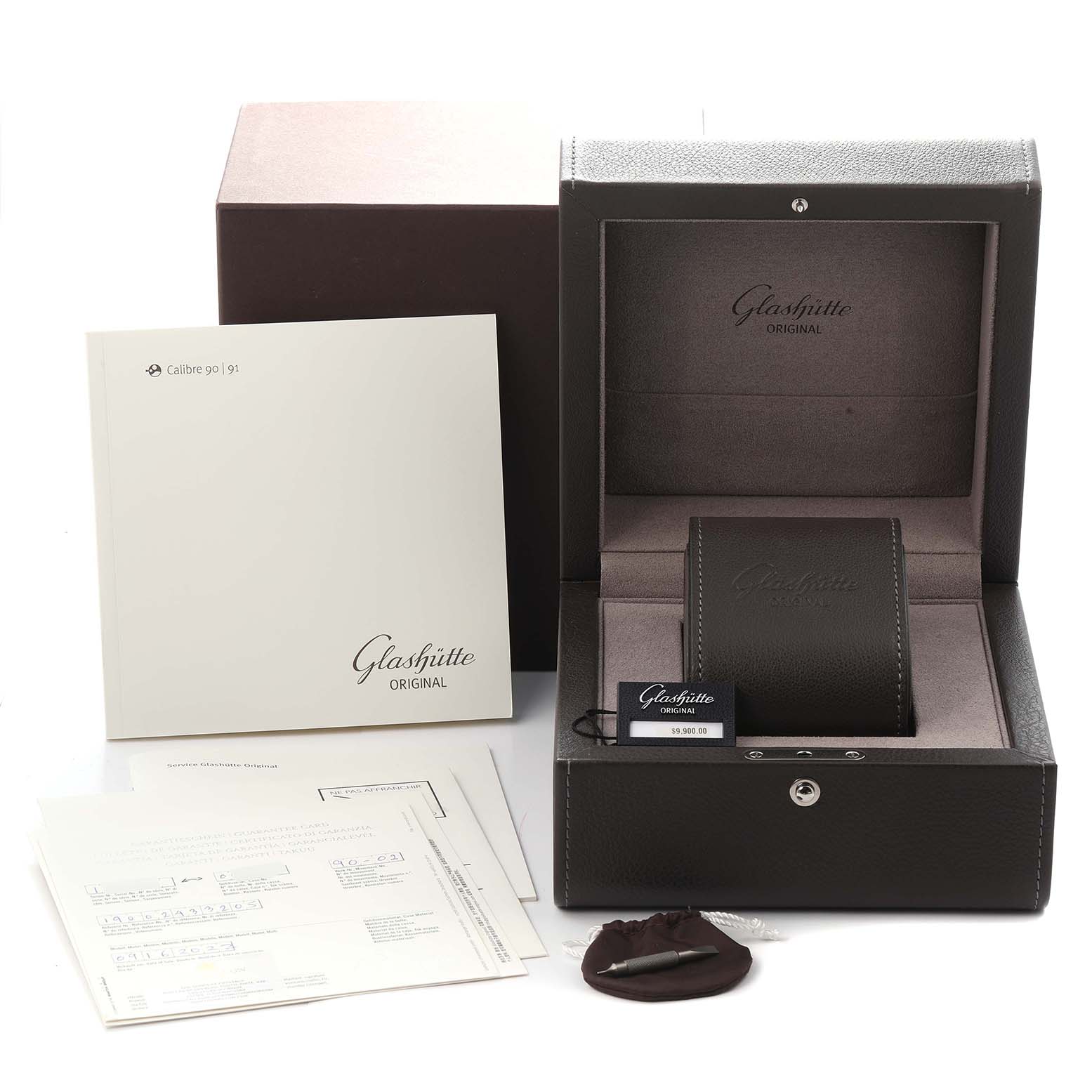 The image shows packaging and accessories for a Glashütte Pano, model number 1-90-02-43-32-05, including a box, manuals, and a tool.