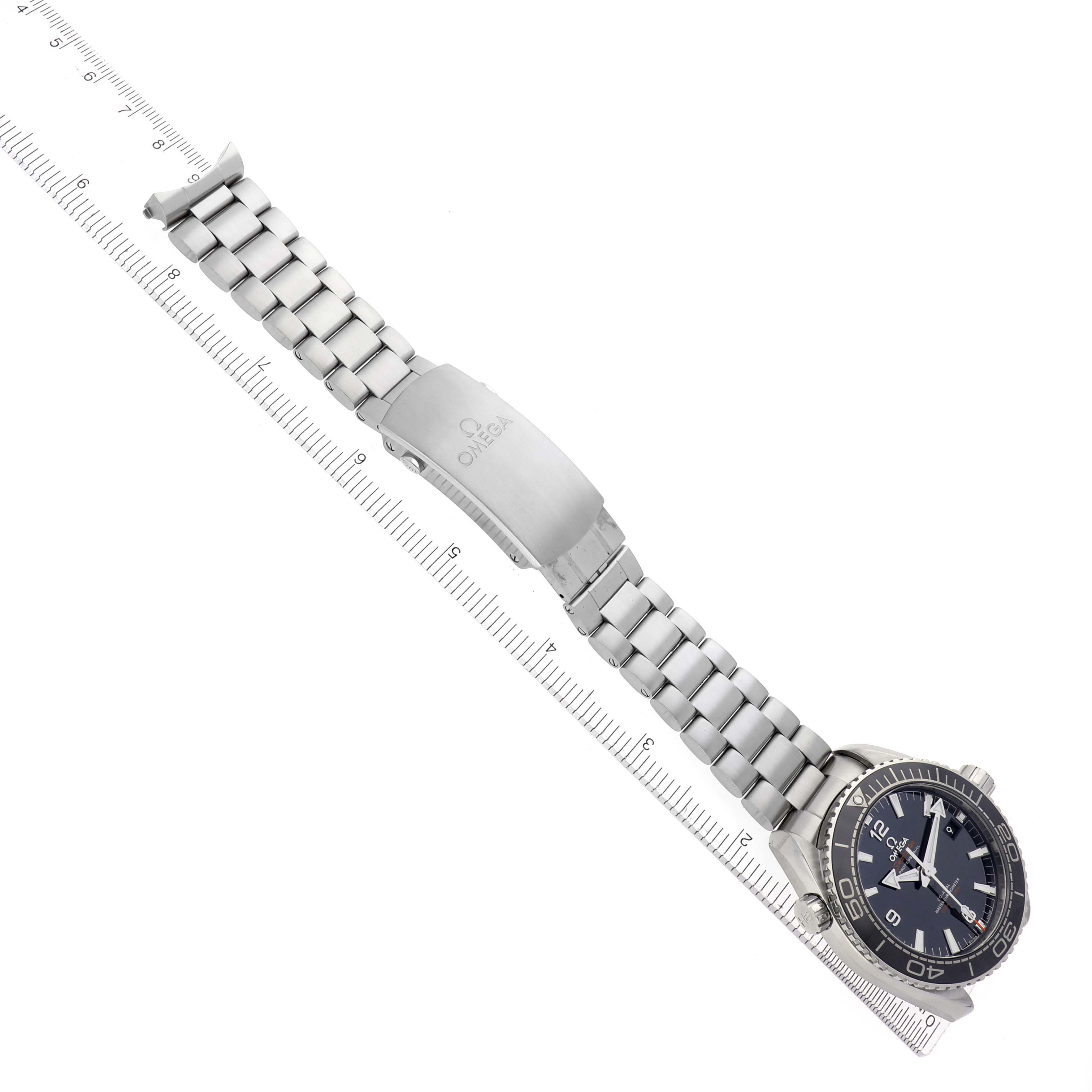 The image shows the Omega Planet Ocean watch model 215.30.44.21.01.001, viewed diagonally with its stainless steel bracelet and clasp, alongside a ruler for scale.