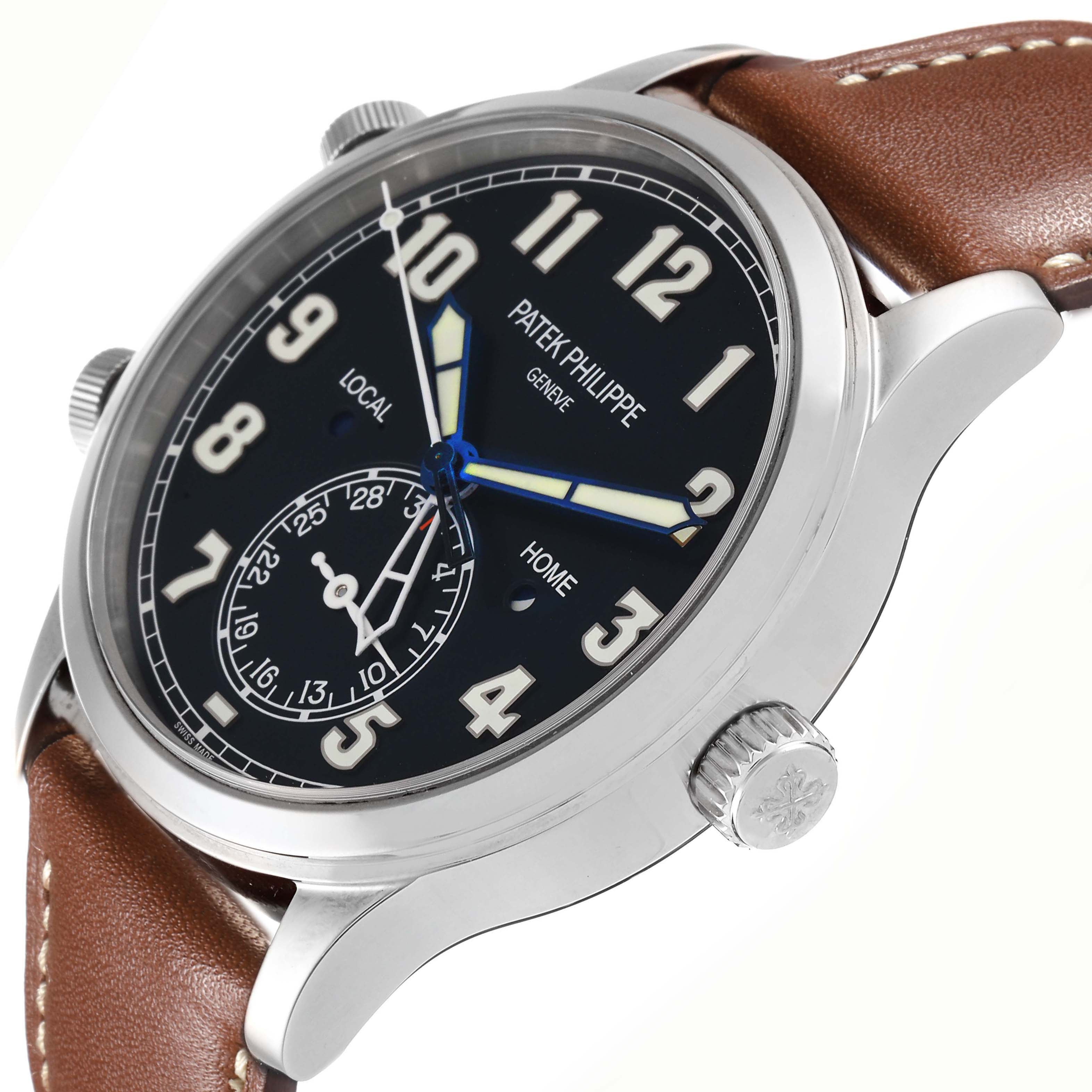 The image shows a Patek Philippe Calatrava 5524G-001 men
s watch at an angle highlighting the black dial, white numerals, blue hands, and brown leather strap.