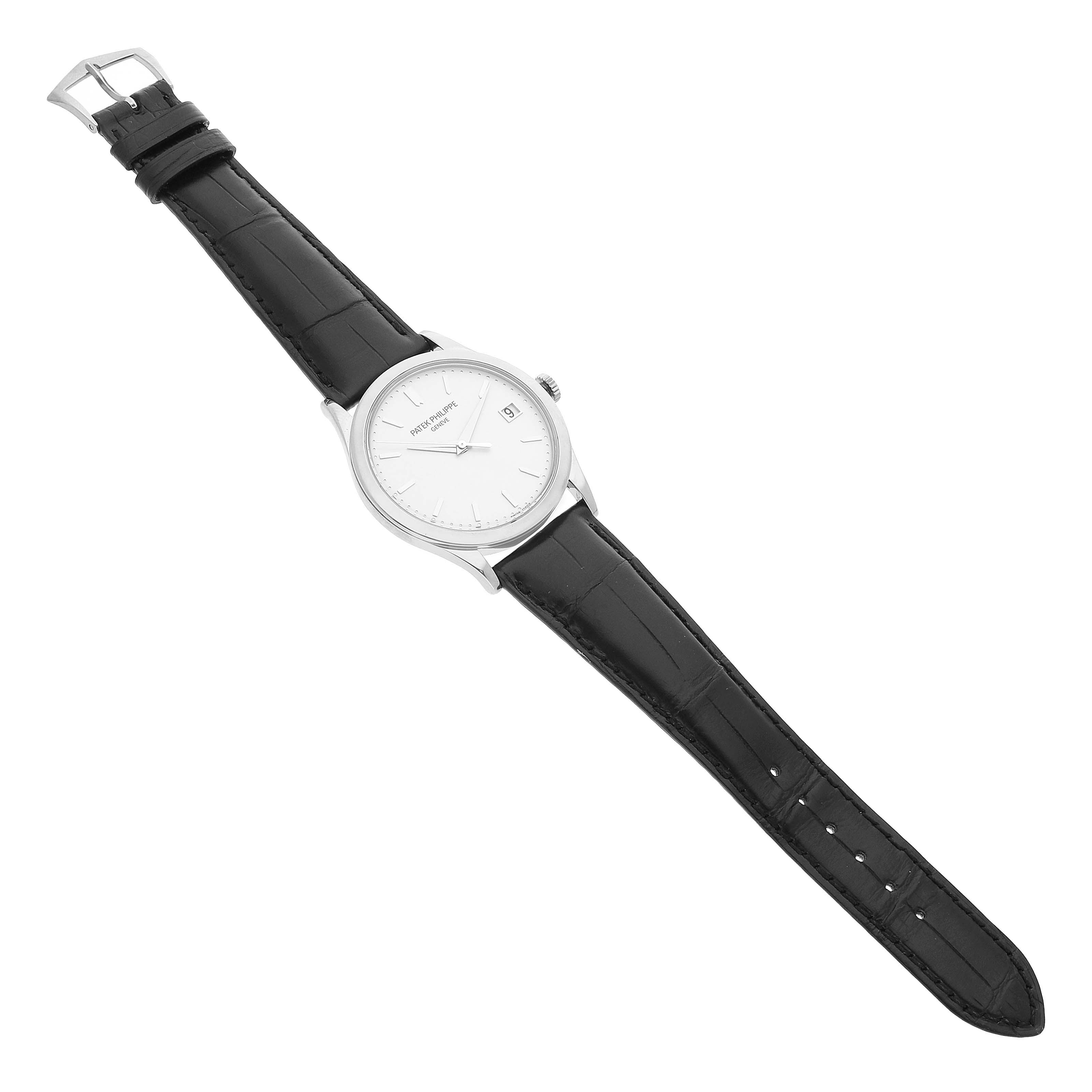 The Patek Philippe Calatrava 5296G-010 Men's White Gold Silver Dial watch is shown from a top-down angle, displaying its dial, case, and black leather strap.