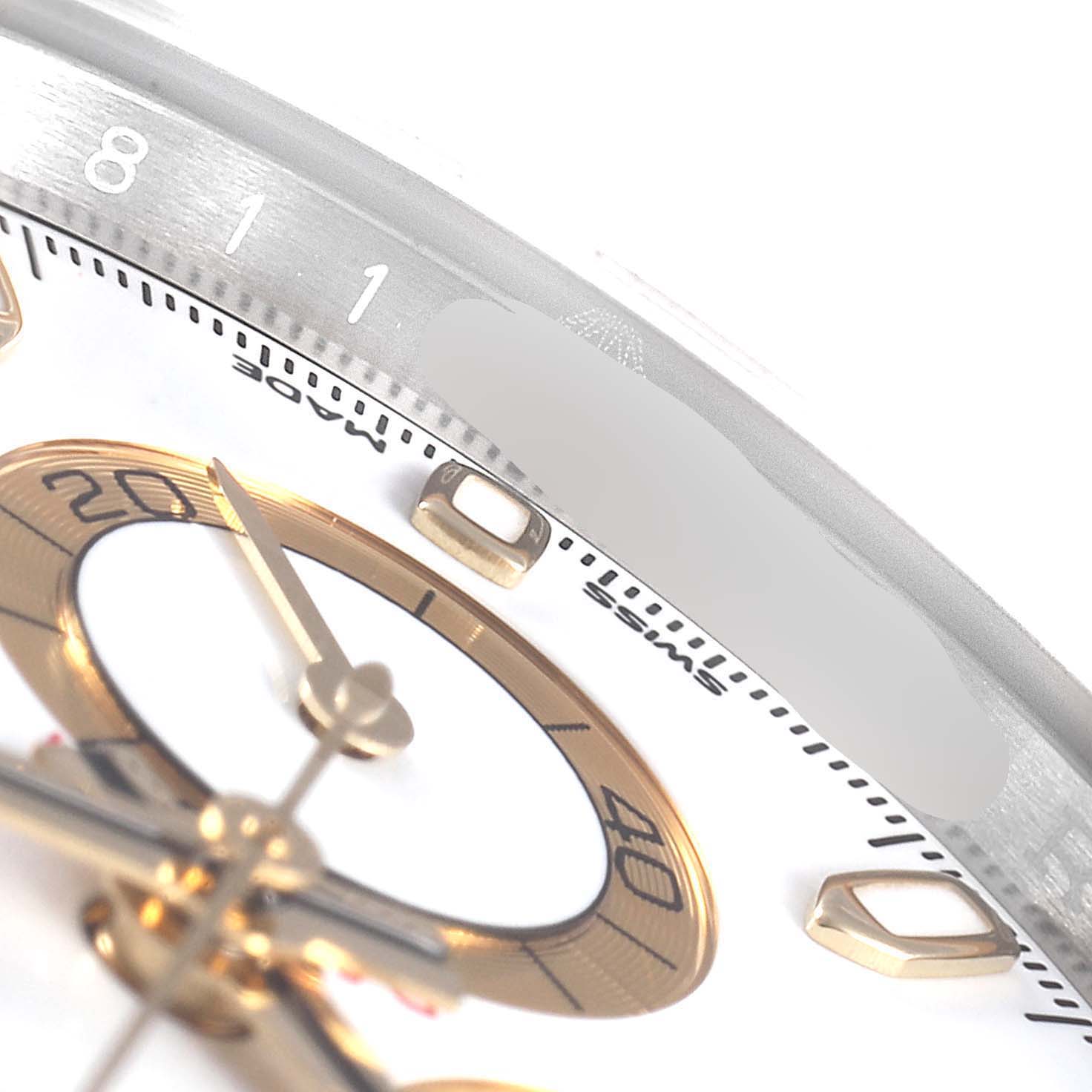 This close-up image of the Rolex Daytona 116503 Men's Steel and Gold (two tone) White Dial 116503 Men's Steel and Gold (two tone) White Dial watch shows parts of the dial, sub-dial, and the bezel with some markers visible.
