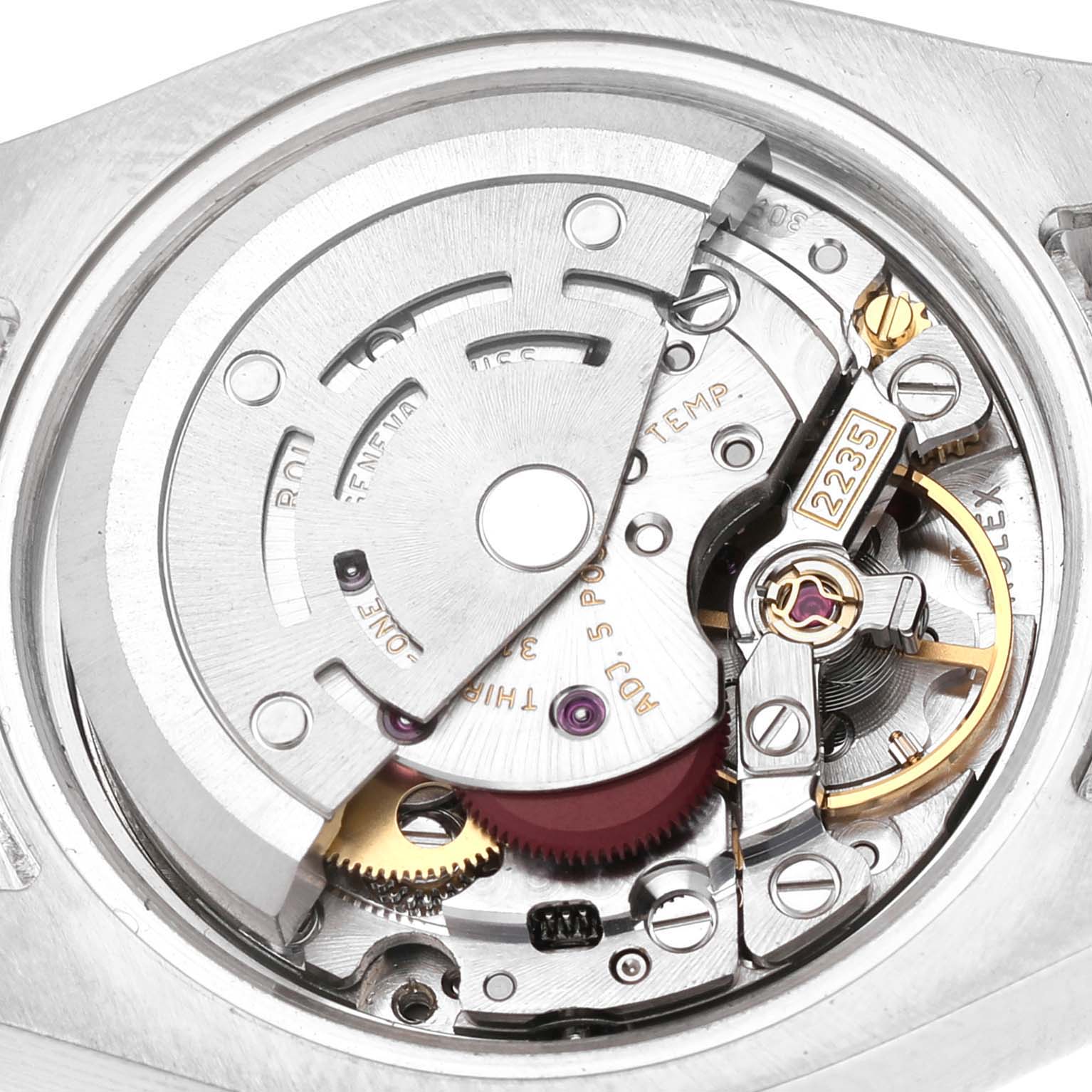 The image shows a detailed view of the movement inside a Rolex Datejust 179384 Women's Stainless Steel Blue Dial, focusing on gears and mechanical components.