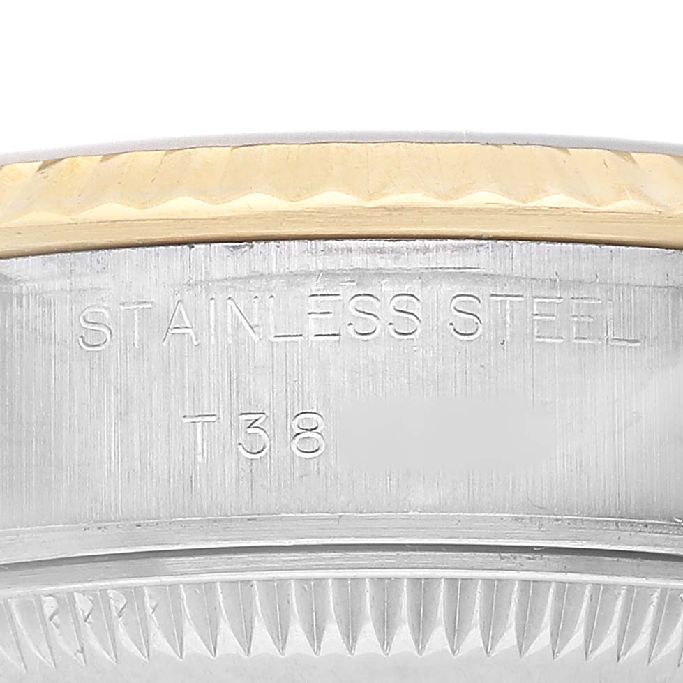 The image shows a close-up of the side of a Rolex Datejust 69173 Women's Stainless Steel Champagne Dial watch case, highlighting the bezel and stainless steel engraving.