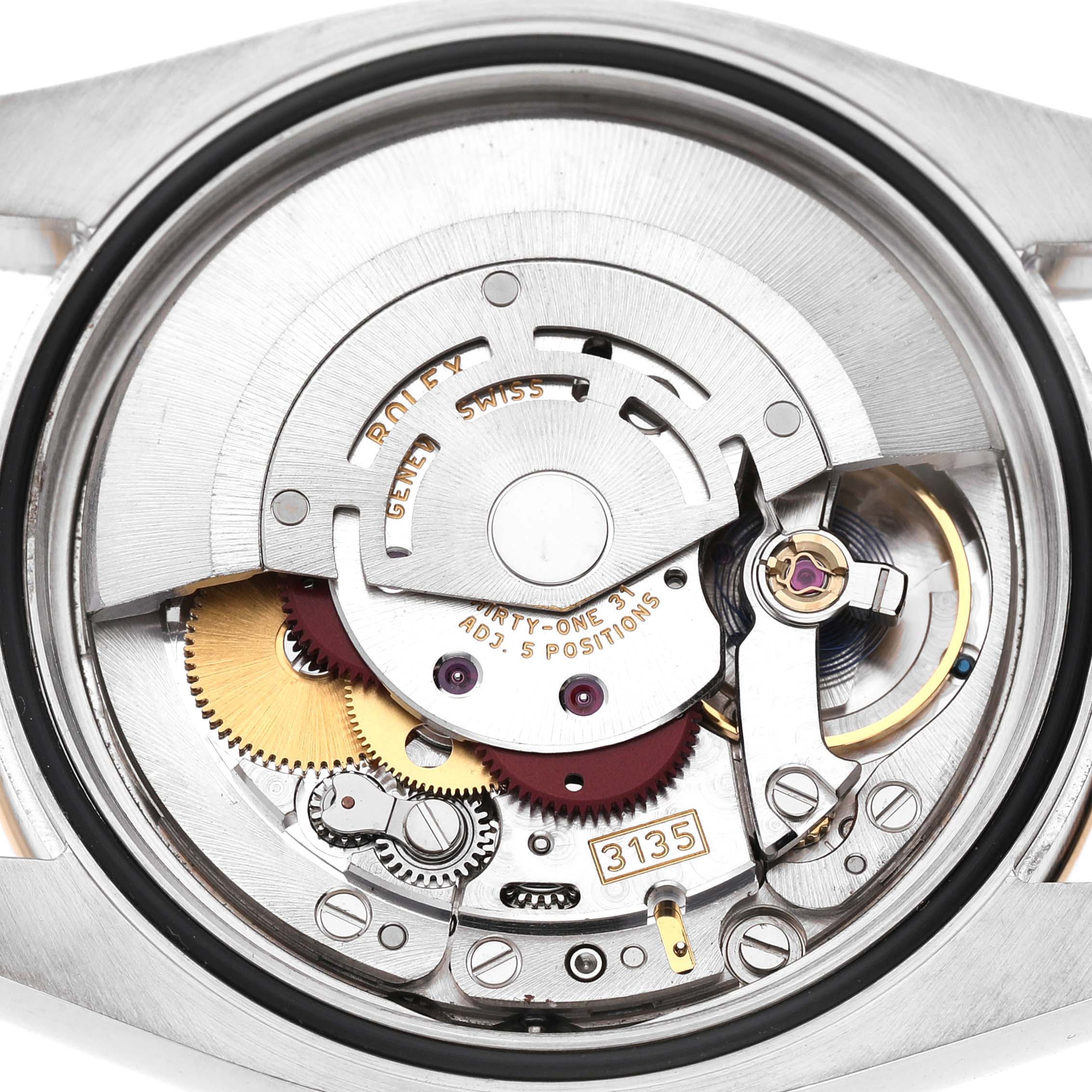 The image shows the back of a Rolex Datejust 116243 Men's Stainless Steel Silver Dial watch, revealing its intricate movement and components from a close-up angle.