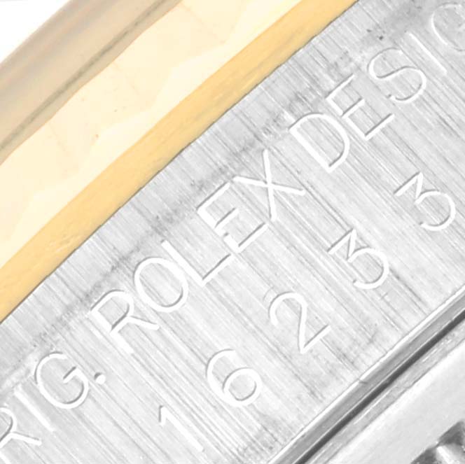 This close-up image shows the engraved side of a Rolex Datejust 16233 Men's Steel and Gold (two tone) Blue Dial 16233 Men's Steel and Gold (two tone) Blue Dial watch case, featuring part of the model number.
