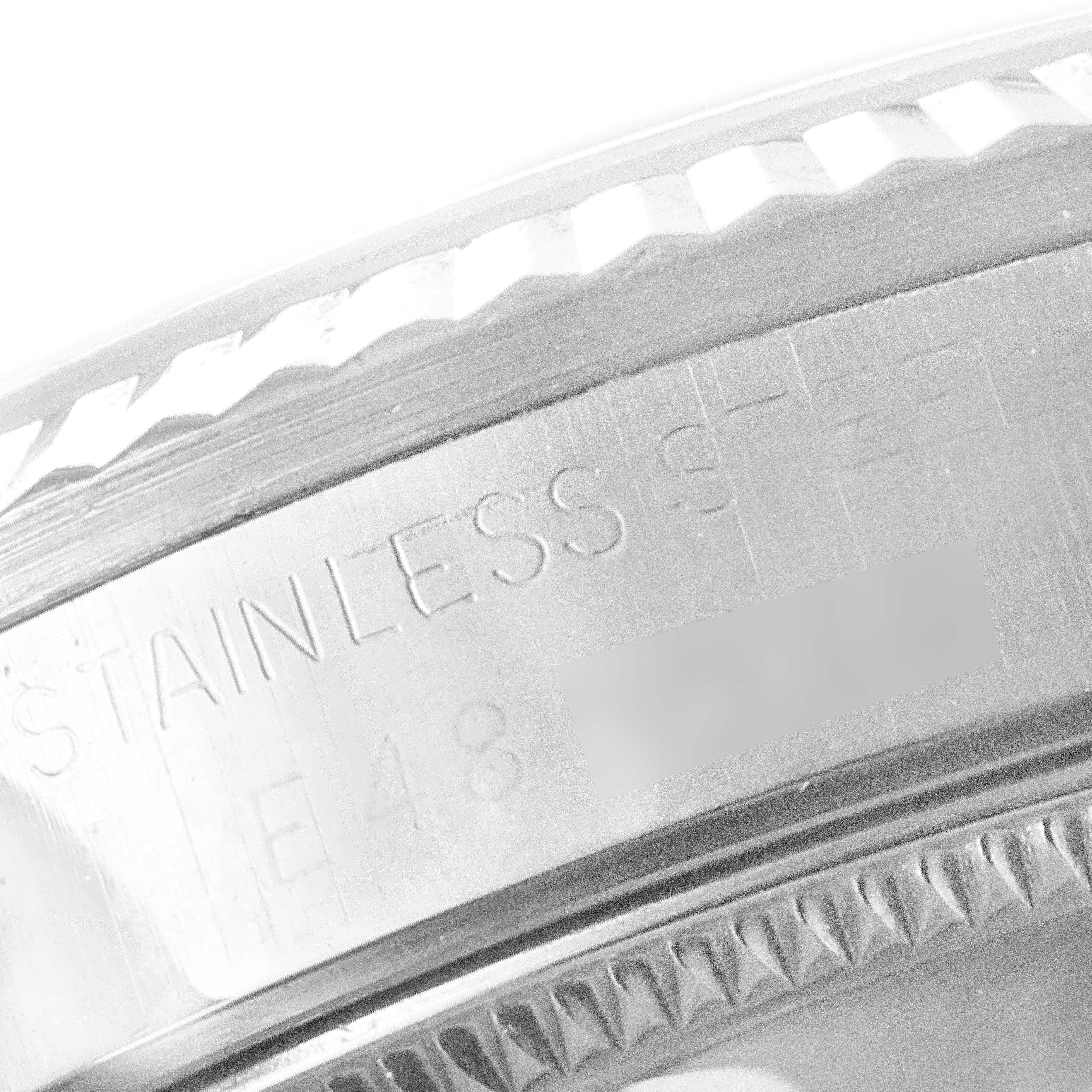 This close-up image shows the stainless steel bezel and case side of a mid-size Rolex watch.