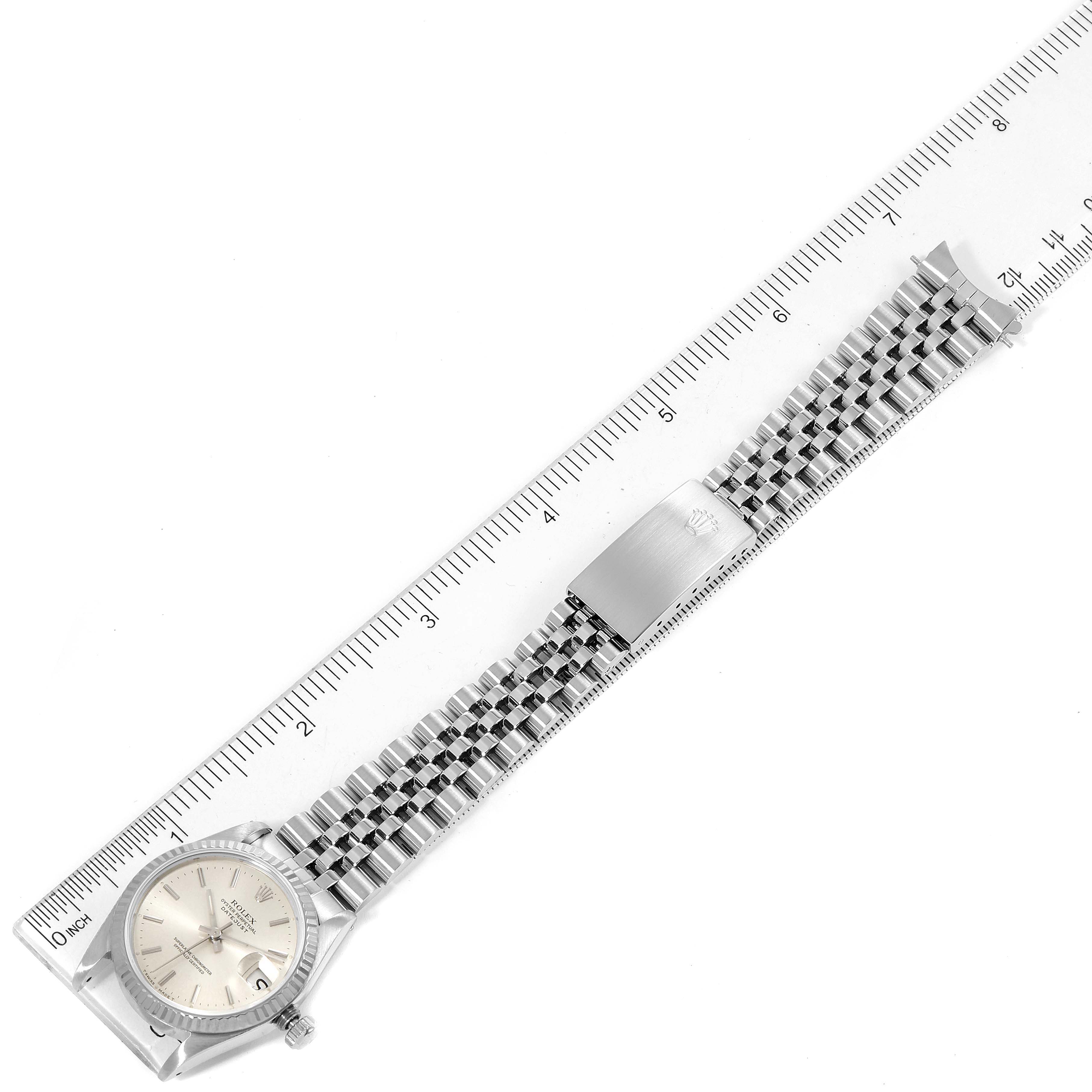 The image shows a Mid-Size Rolex watch laid flat next to a ruler, displaying its face and entire bracelet.