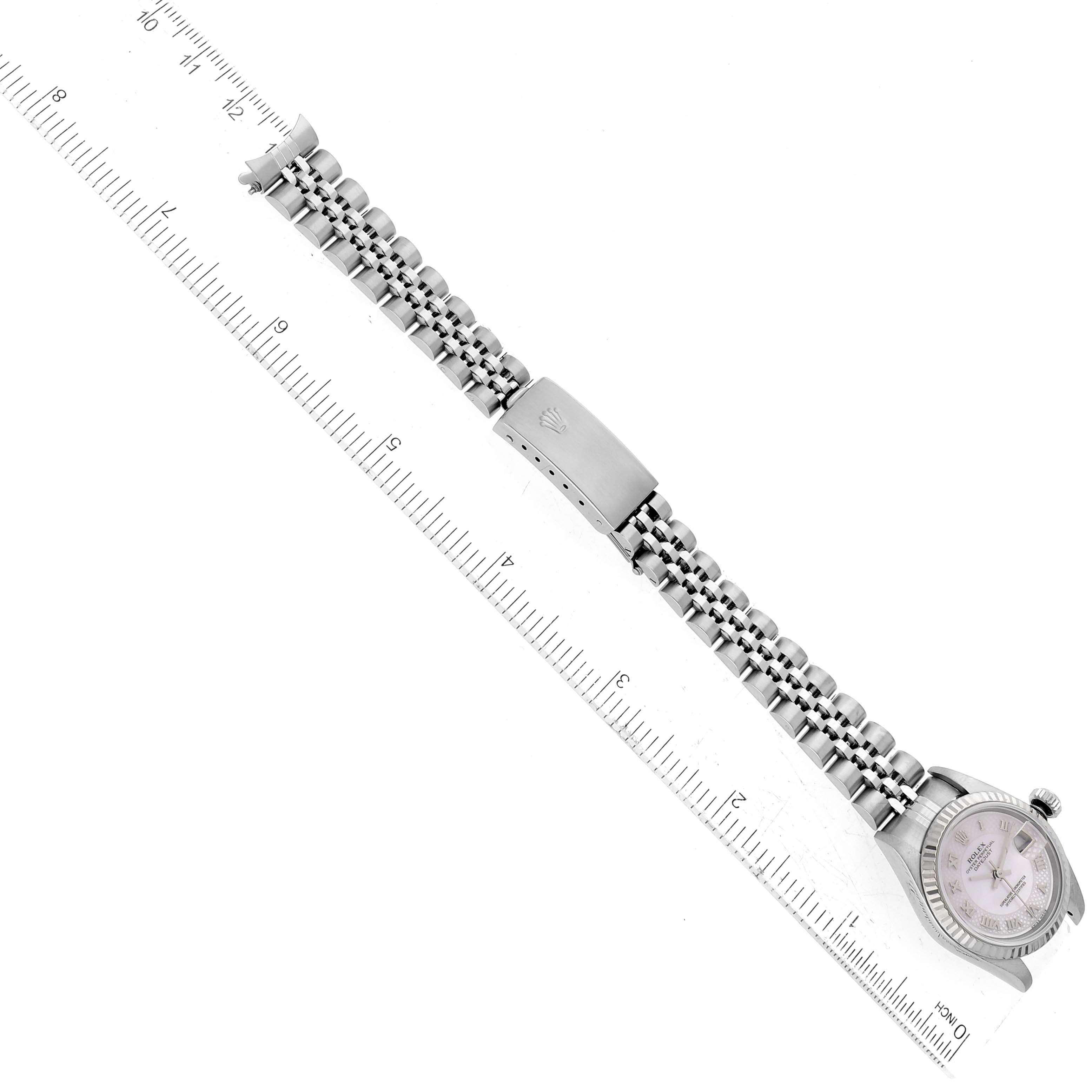 The image shows a Rolex Datejust 79174 Women's Stainless Steel Mother of Pearl Dial 79174 Women's Stainless Steel Mother of Pearl Dial watch laid flat, highlighting its bracelet with the clasp open and a ruler for scale.