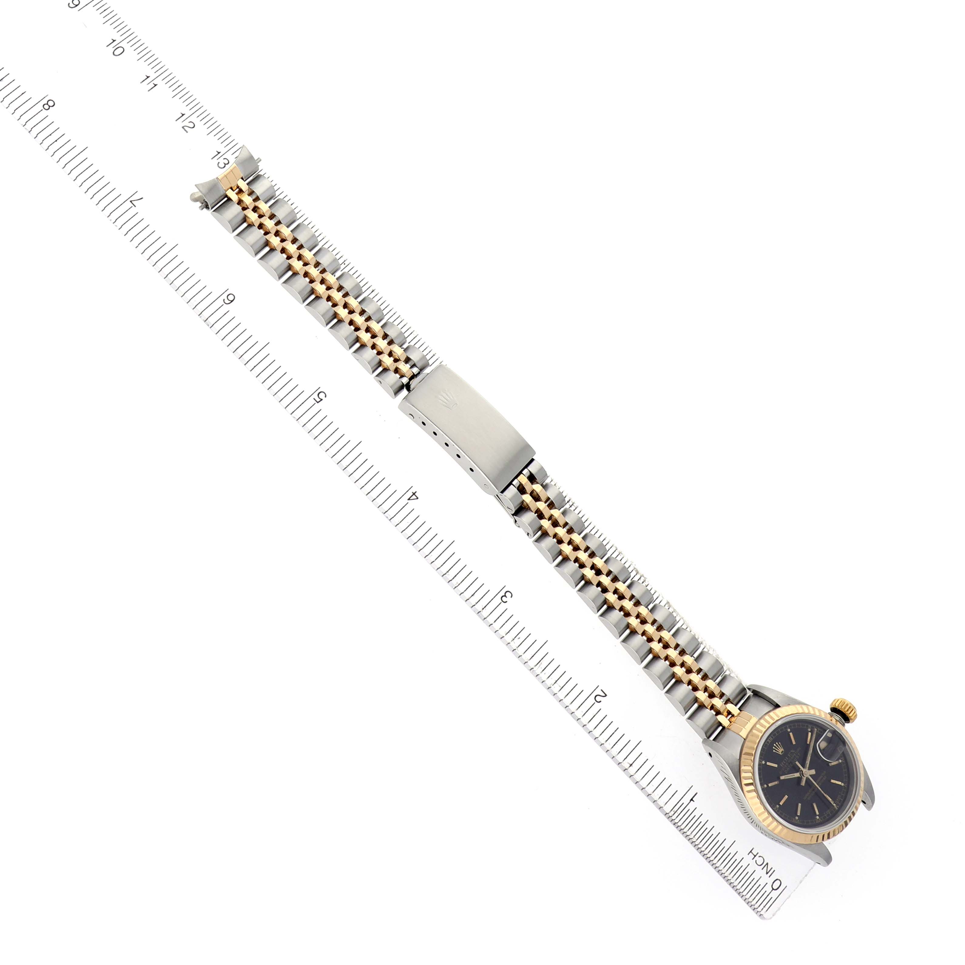 The image shows a Rolex Datejust model 69173 men's watch laid flat at an angle, displaying its two-tone bracelet, clasp, and face next to a ruler.