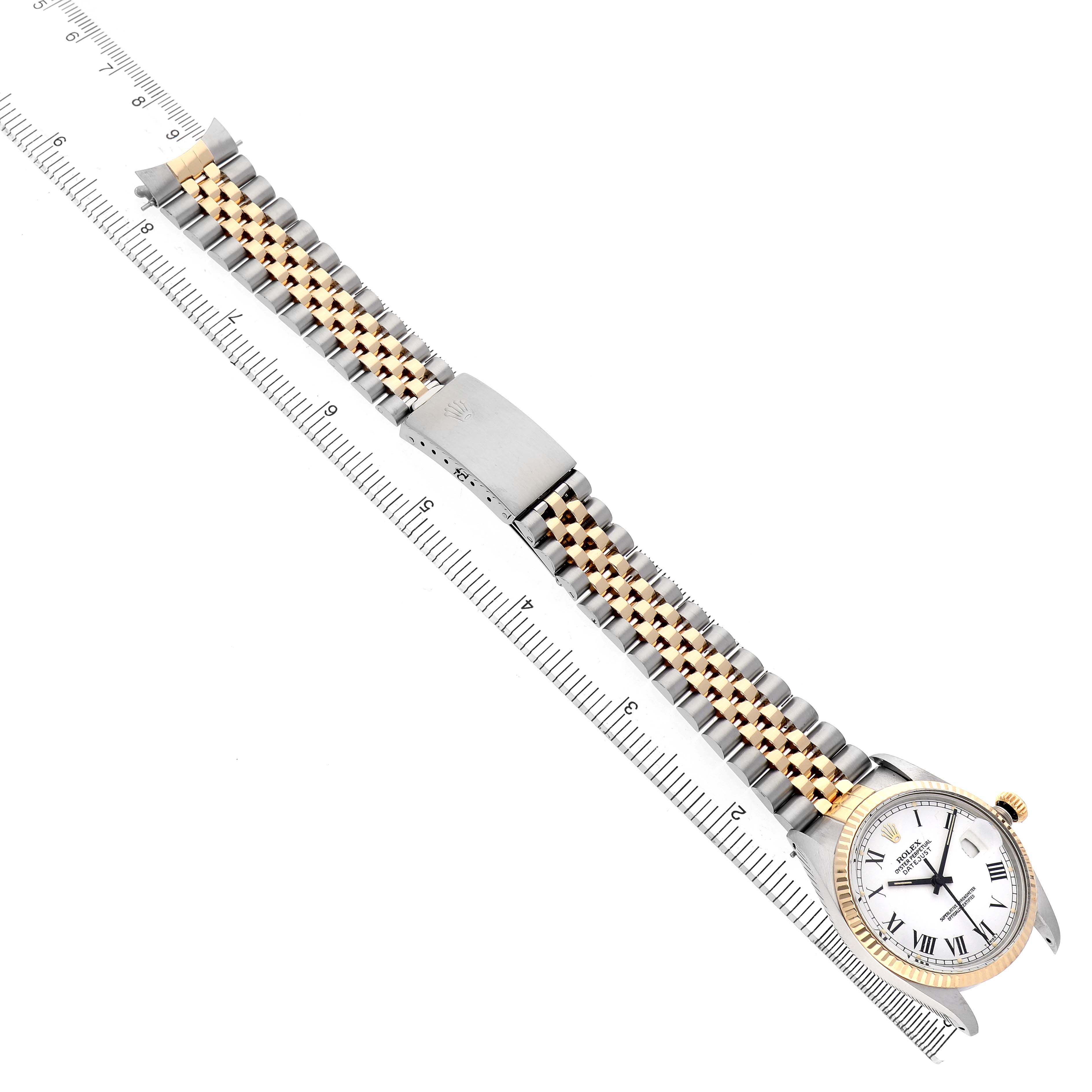 The Rolex Vintage Collection 16013 Men's Steel and Gold (two tone) White Dial watch is shown from an angled top view, featuring its face, bezel, and two-tone bracelet aligned alongside a ruler.