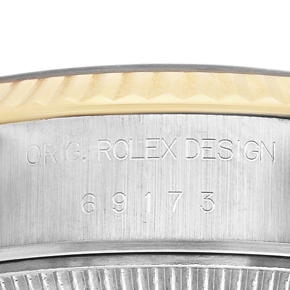 This close-up image of a Rolex Datejust 69173 Women's Steel and Gold (two tone) Champagne Dial 69173 Women's Steel and Gold (two tone) Champagne Dial watch shows the engraved model number and part of the fluted bezel.