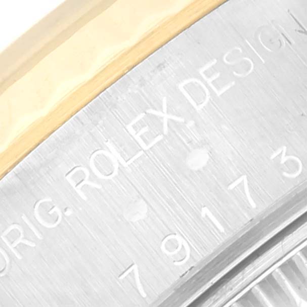 This close-up image shows the engraved text on the side of a Rolex Datejust 79173 Women's Steel and Gold (two tone) Grey Dial 79173 Women's Steel and Gold (two tone) Grey Dial model watch.
