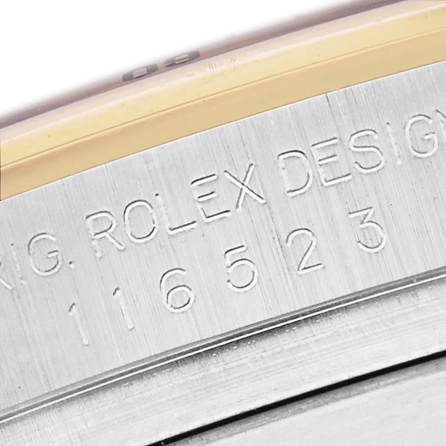 The image shows a close-up of the side of a Rolex Daytona watch, model number 116523, with the engraved text "ROLEX DESIGN 116523."