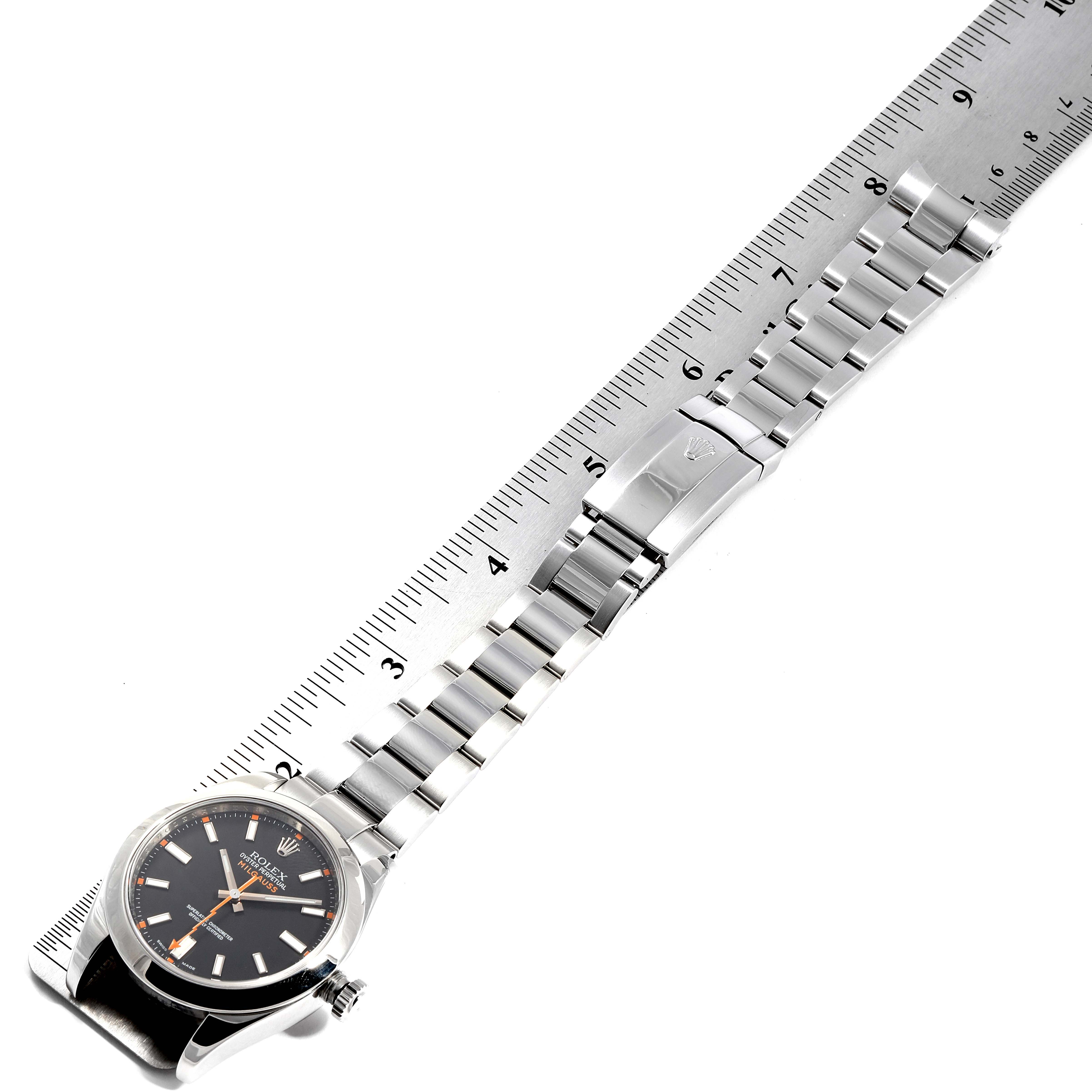 The image shows a top-down view of a Rolex Milgauss 116400 Men's Stainless Steel Black Dial 116400 Men's Stainless Steel Black Dial watch with a stainless steel bracelet placed alongside a ruler.