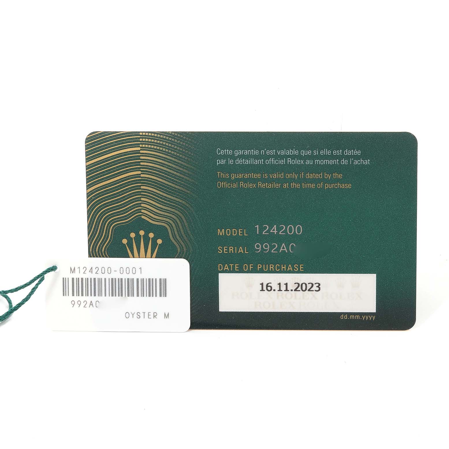 The image shows the warranty card and tag of a Rolex Oyster Perpetual 124200 Men's Stainless Steel Silver Dial 124200 Men's Stainless Steel Silver Dial model 124200 with serial number 992AC.