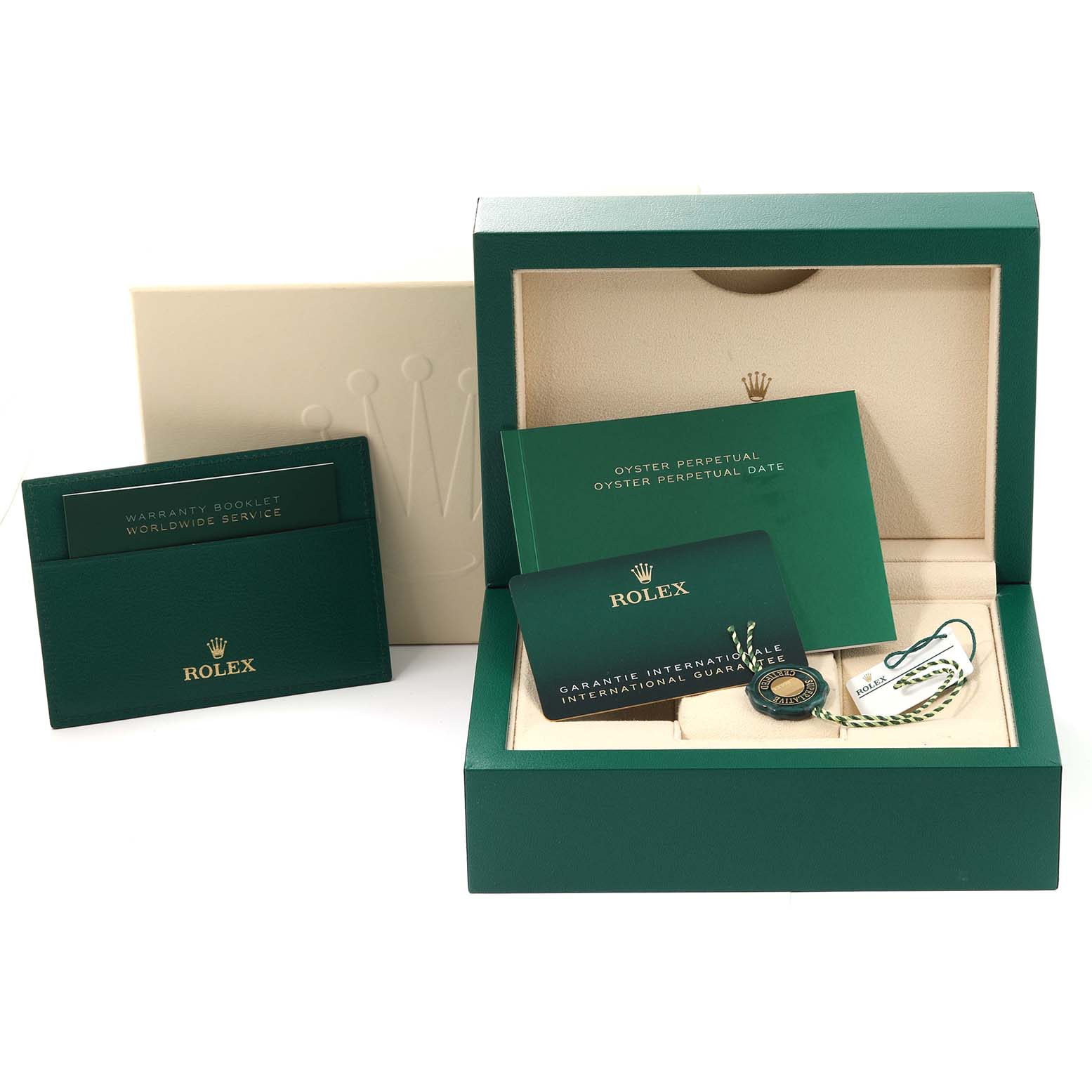 The image shows an Oyster Perpetual Rolex watch box, warranty booklets, international guarantee card, and tag from a front angle.