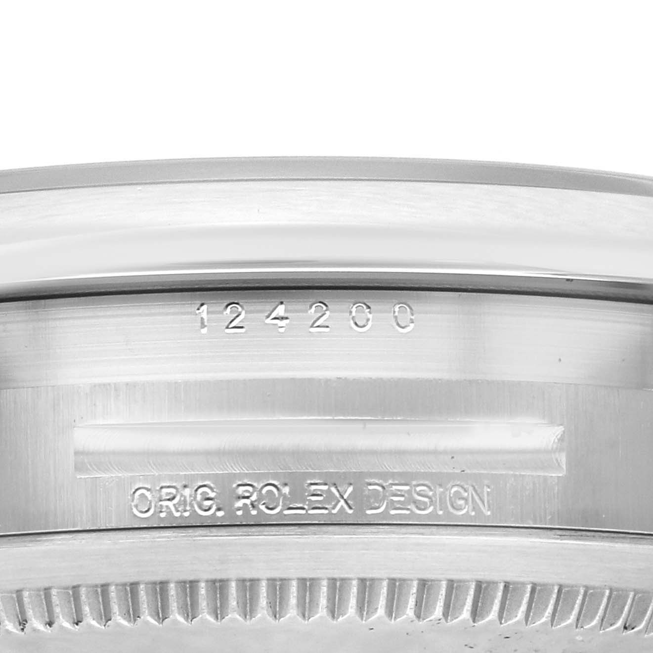 This close-up image shows the side of the Rolex Oyster Perpetual 124200 Men's Stainless Steel Silver Dial 124200 Men's Stainless Steel Silver Dial with model number 124200 and "ORIG. ROLEX DESIGN" engraved.