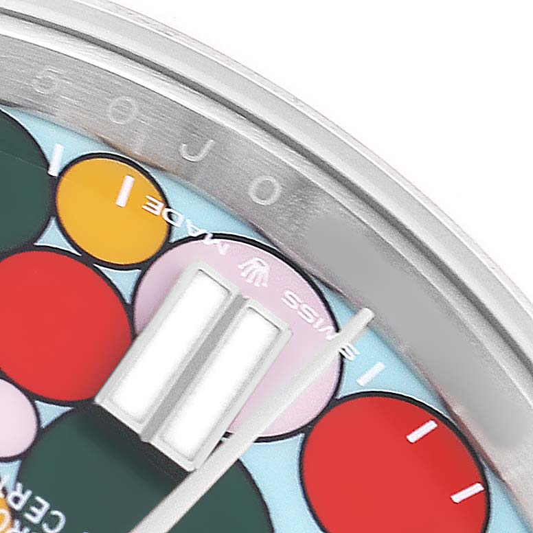 The image shows a close-up of the dial's edge and colorful face of a Rolex Oyster Perpetual 124300 Men's Stainless Steel Blue Dial watch.