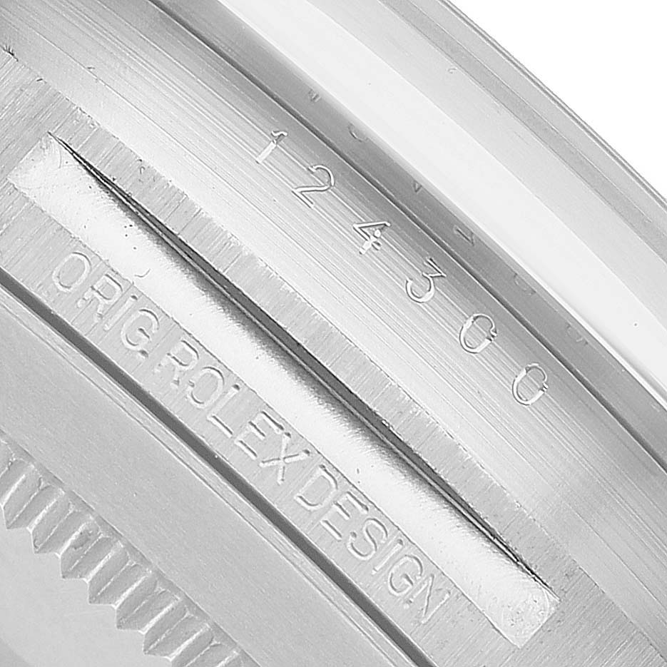 The image shows a close-up of the model number and "Orig Rolex Design" engraving on the casing of a Rolex Oyster Perpetual 124300 Men's Stainless Steel Blue Dial watch.