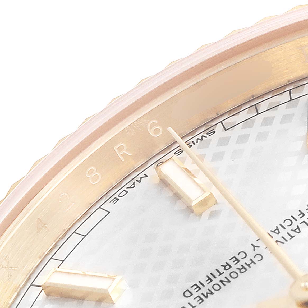 This close-up image of a Rolex President 228238 Men's Yellow Gold Silver Dial 228238 Men's Yellow Gold Silver Dial watch shows part of the bezel, dial, and hour markers from an oblique angle.