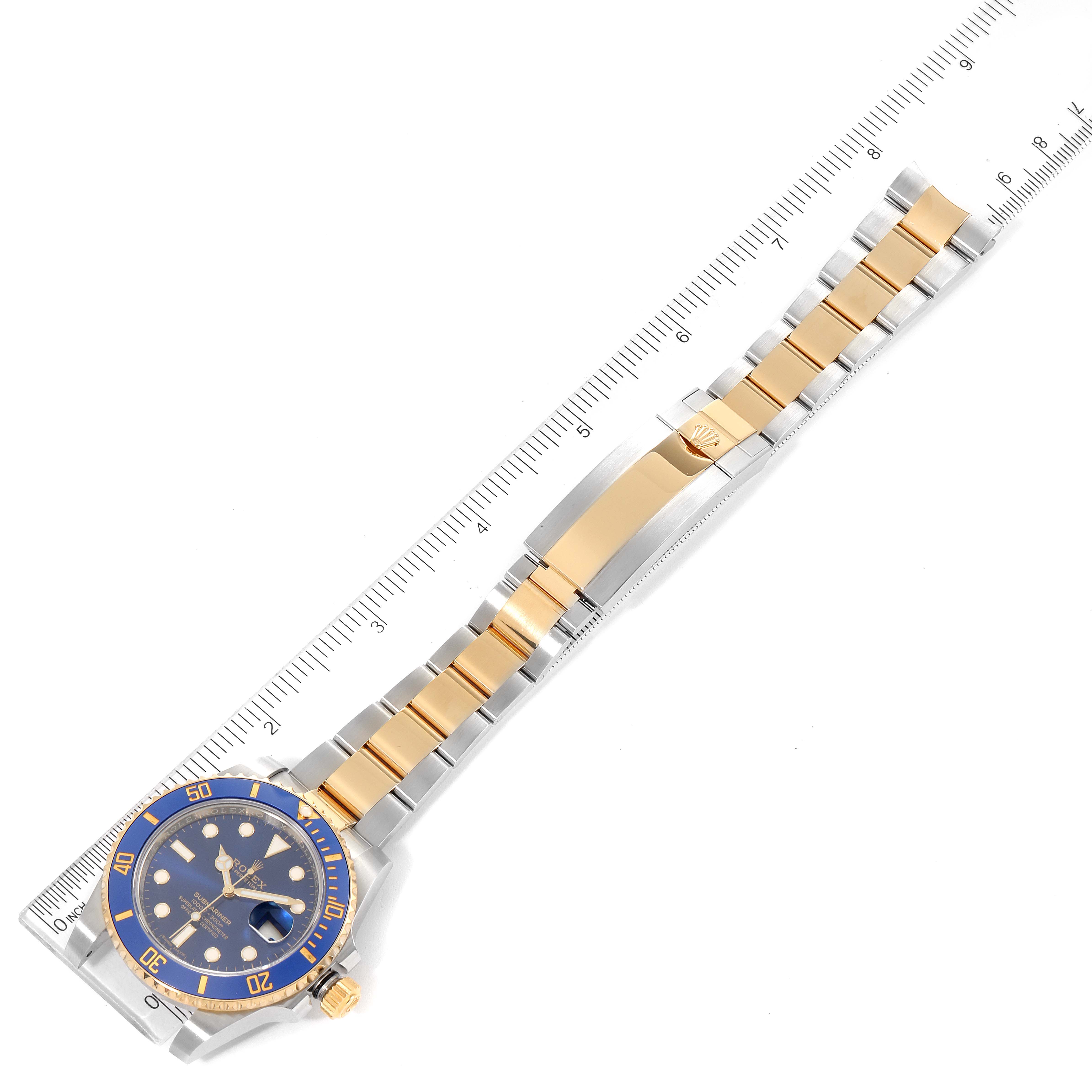 The image shows a top-down view of a Rolex Submariner 116613 Men's Steel and Gold (two tone) Blue Dial 116613 Men's Steel and Gold (two tone) Blue Dial watch, displaying the face, bezel, and full length of the bracelet with a ruler alongside.