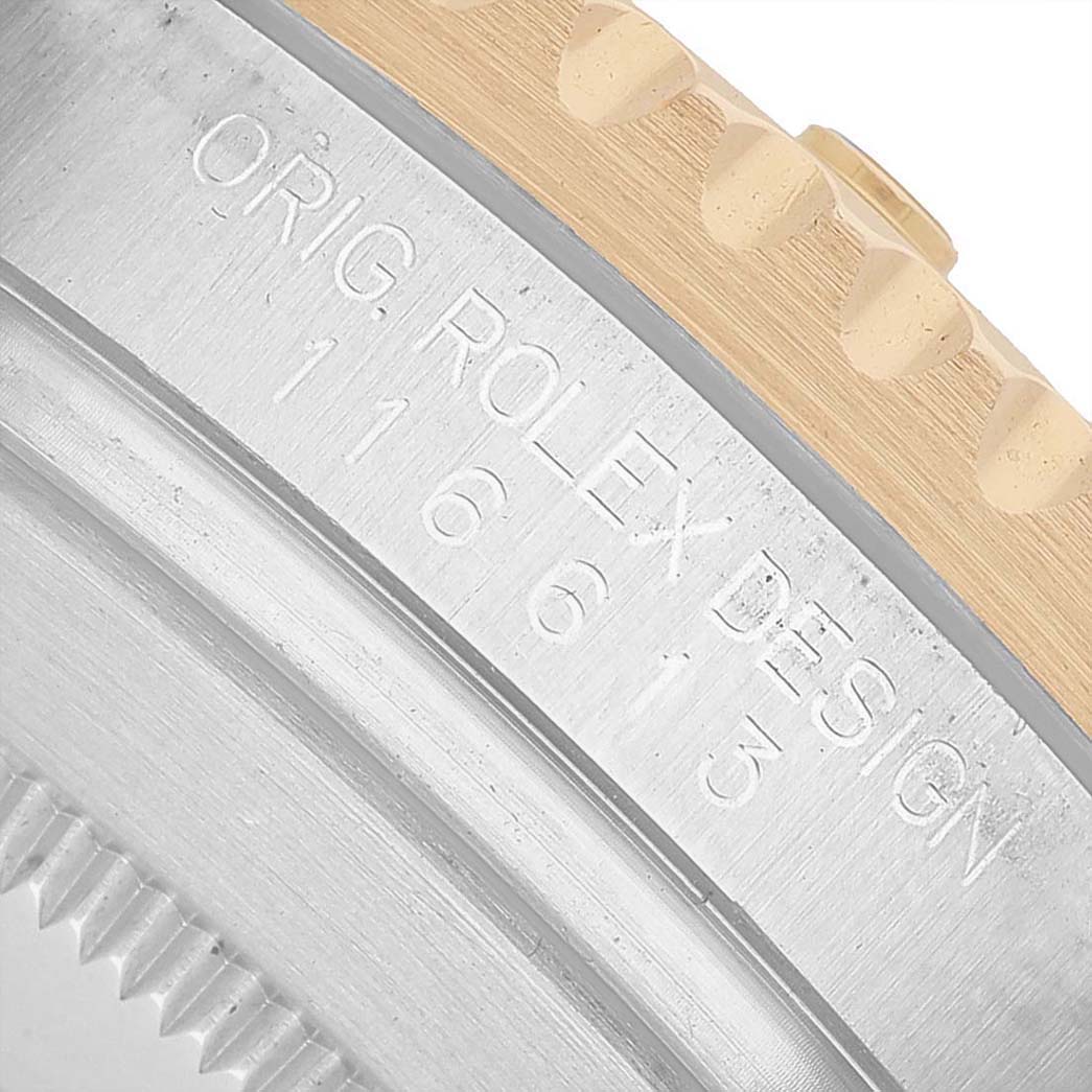 This image shows a close-up angle of the bezel and side of a Rolex Submariner 116613 Men's Steel and Gold (two tone) Black Dial, highlighting its engraved details.