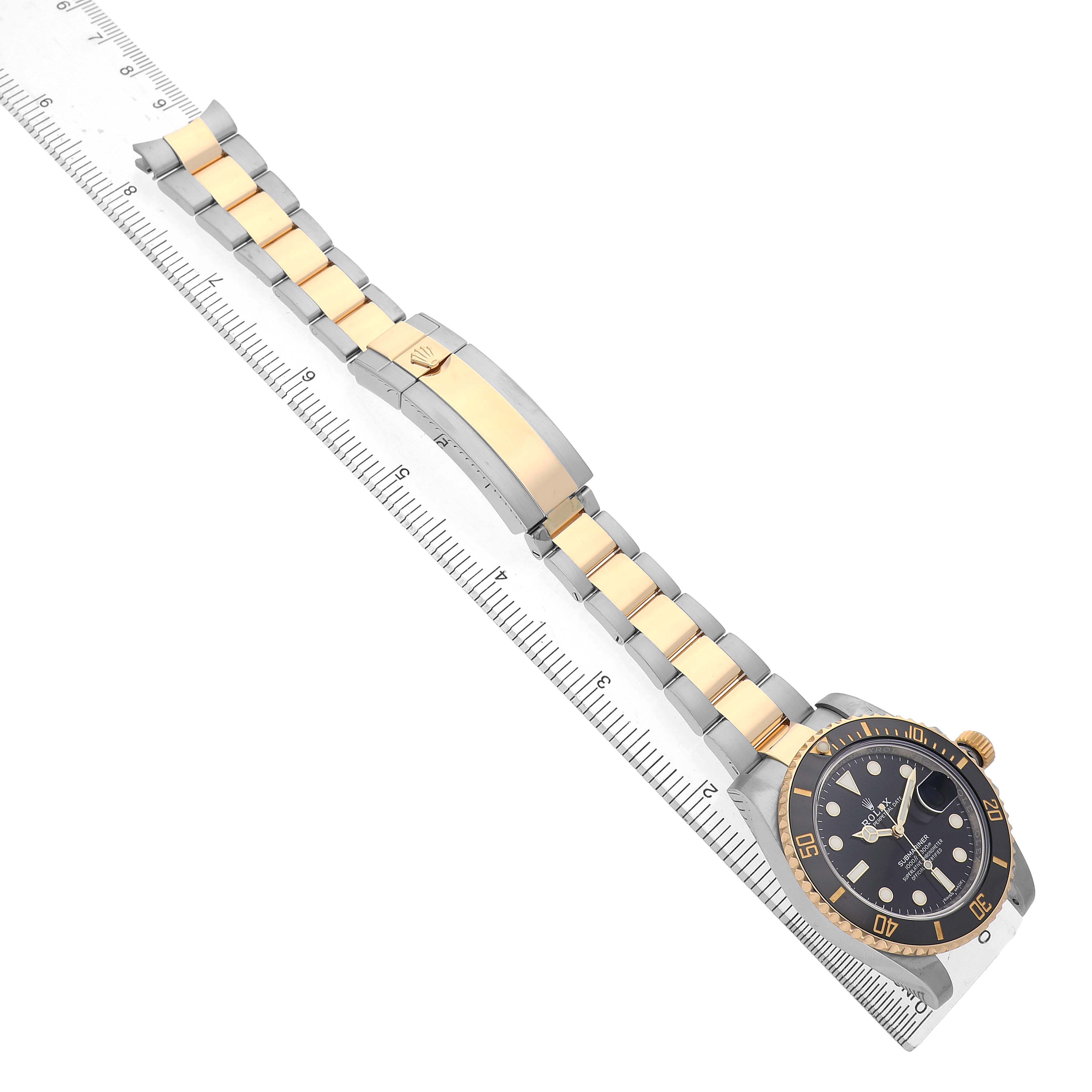 The image shows a Rolex Submariner 116613 Men's Steel and Gold (two tone) Black Dial at an angled top view, featuring the watch face, bezel, and the bracelet with a clasp.